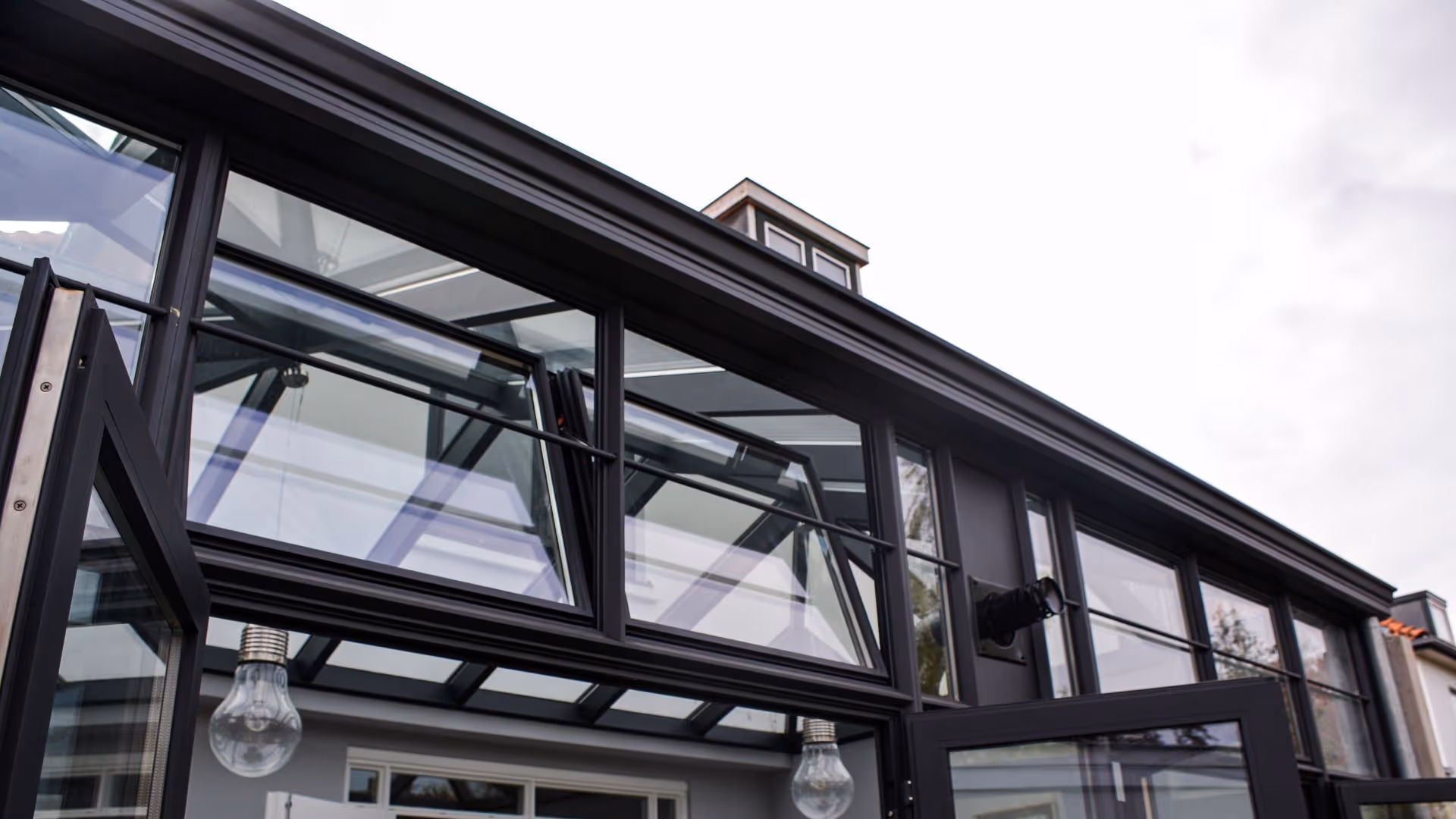 Detailfoto van steellook serre met ventilatieramen, slanke profielen en moderne glasconstructie.