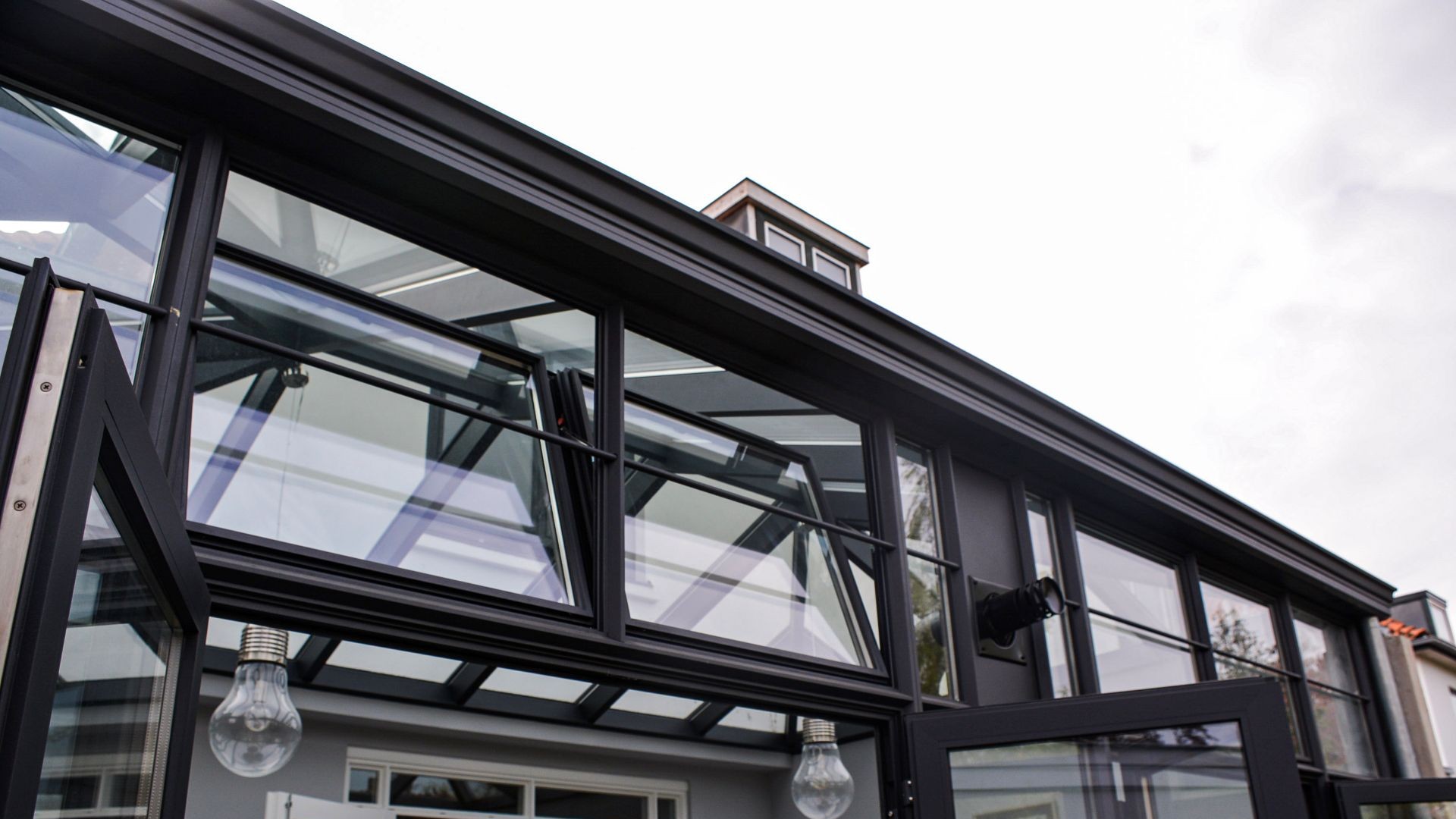 Detailfoto van steellook serre met ventilatieramen, slanke profielen en moderne glasconstructie.