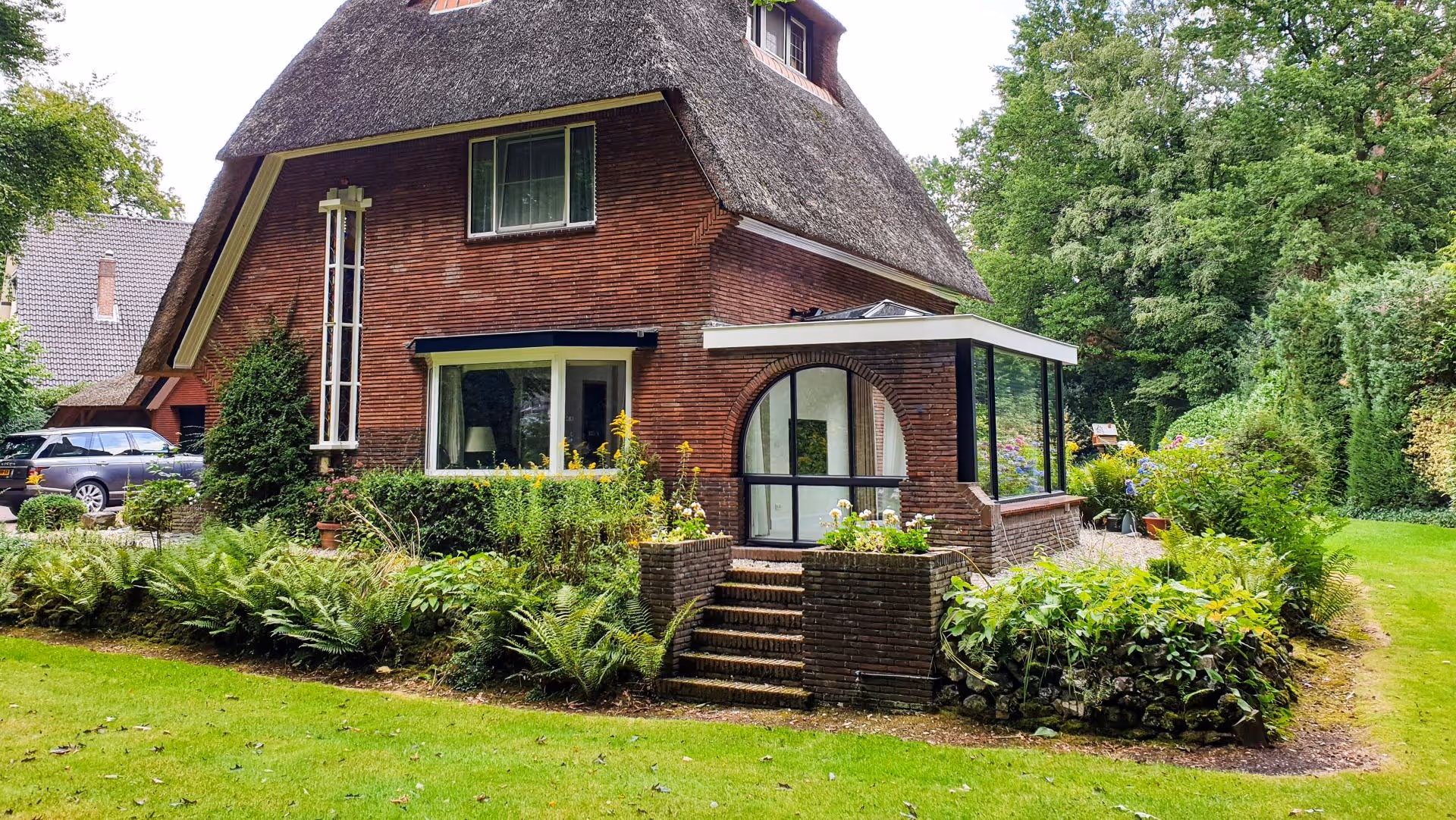 Riante woning met luxe aanbouw, zwarte aluminium kozijnen en veel natuurlijke lichtinval.