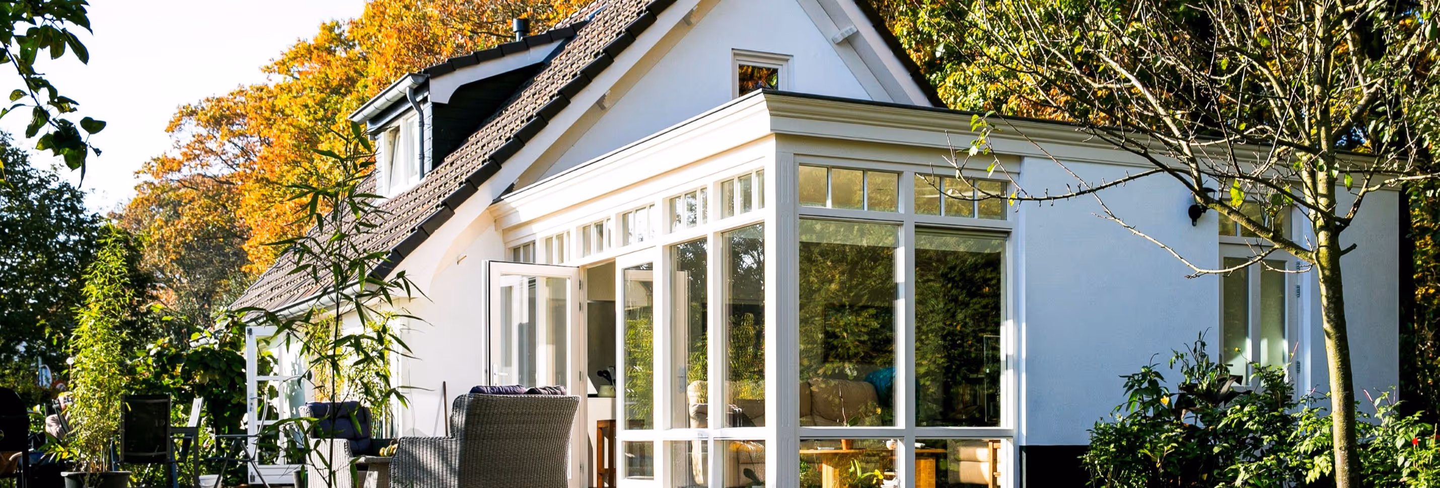 Houten serre Oostendorp - Vrijstaande woning met klassieke serre-aanbouw, witte kozijnen en zonnige bostuin.