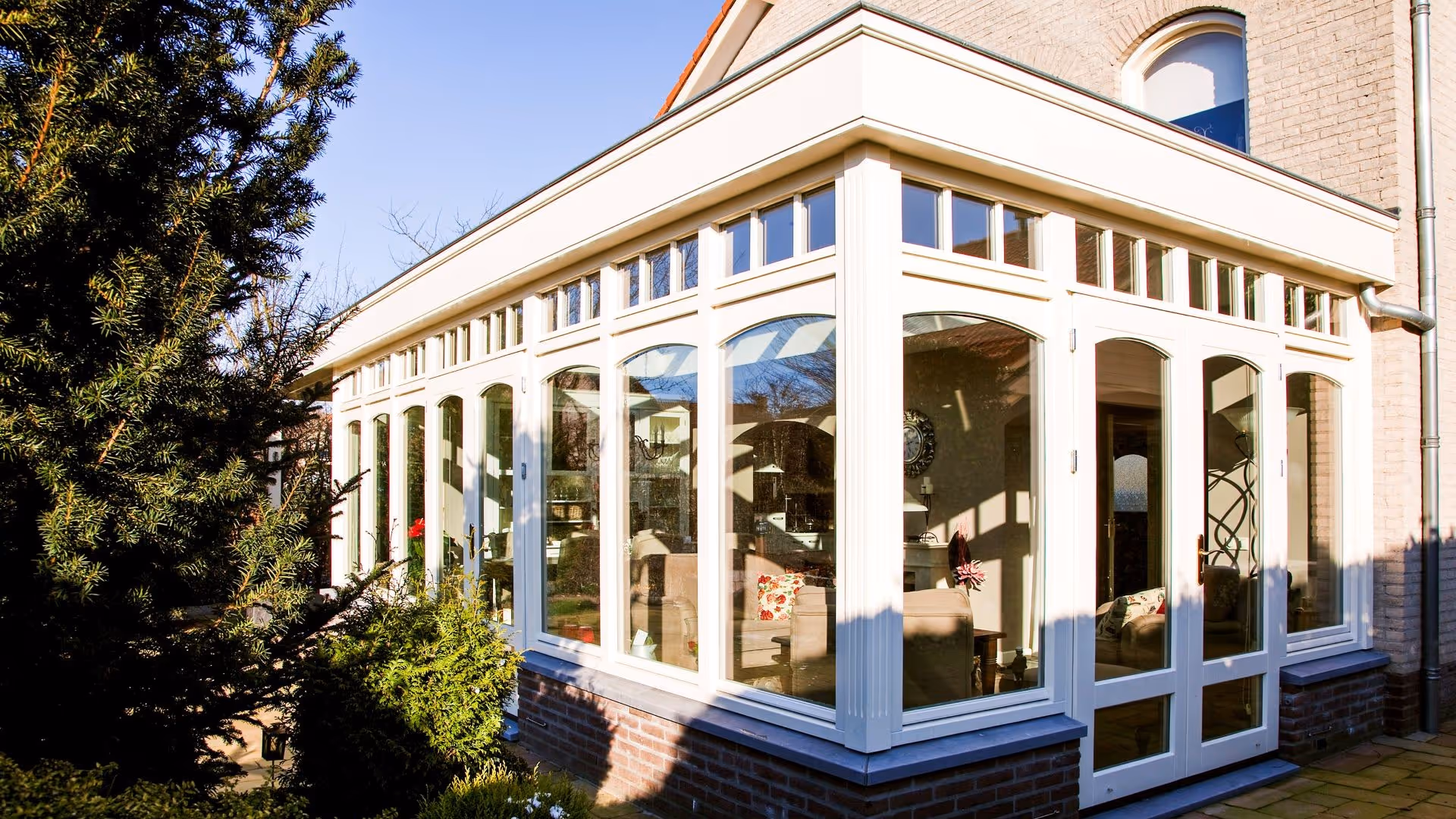 Klassieke witte serre met hoge glaspartijen en lichtstraat aan vrijstaande woning