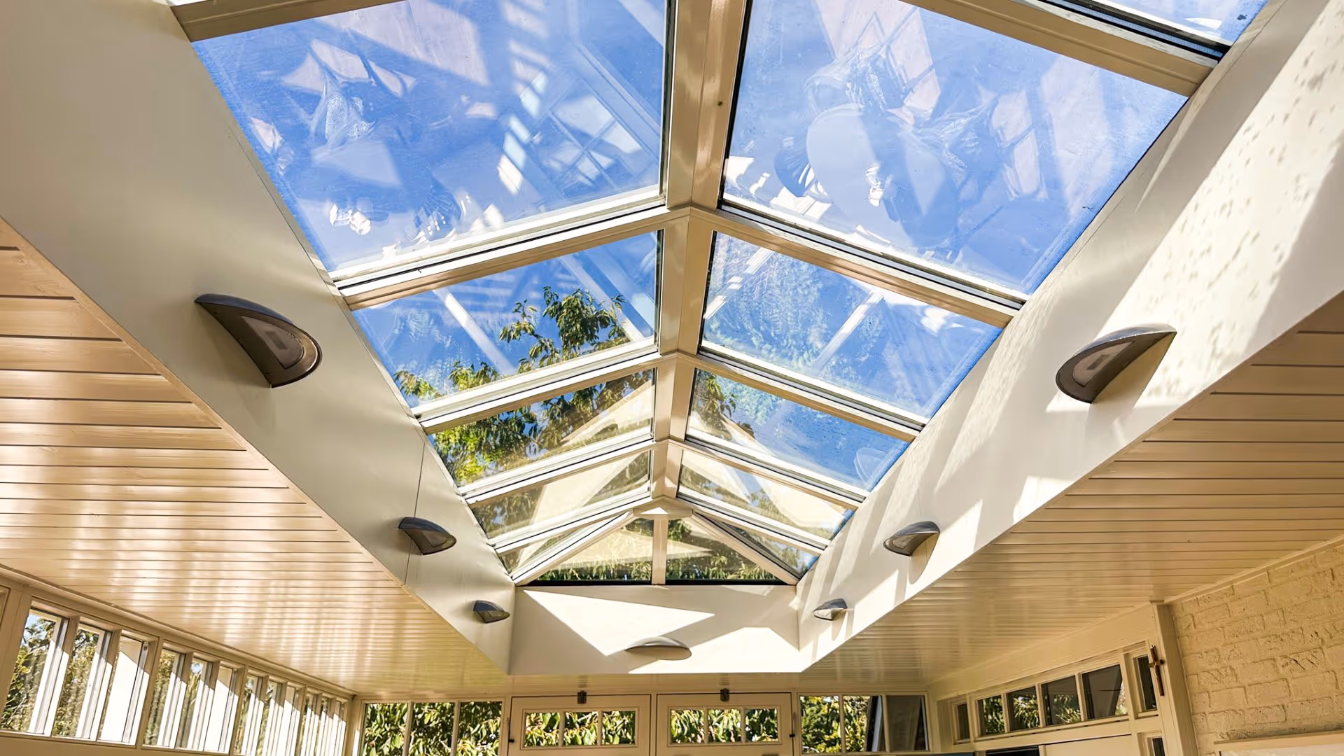 Lichte tuinkamer met glazen gevel, zithoek en directe verbinding met de tuin.
