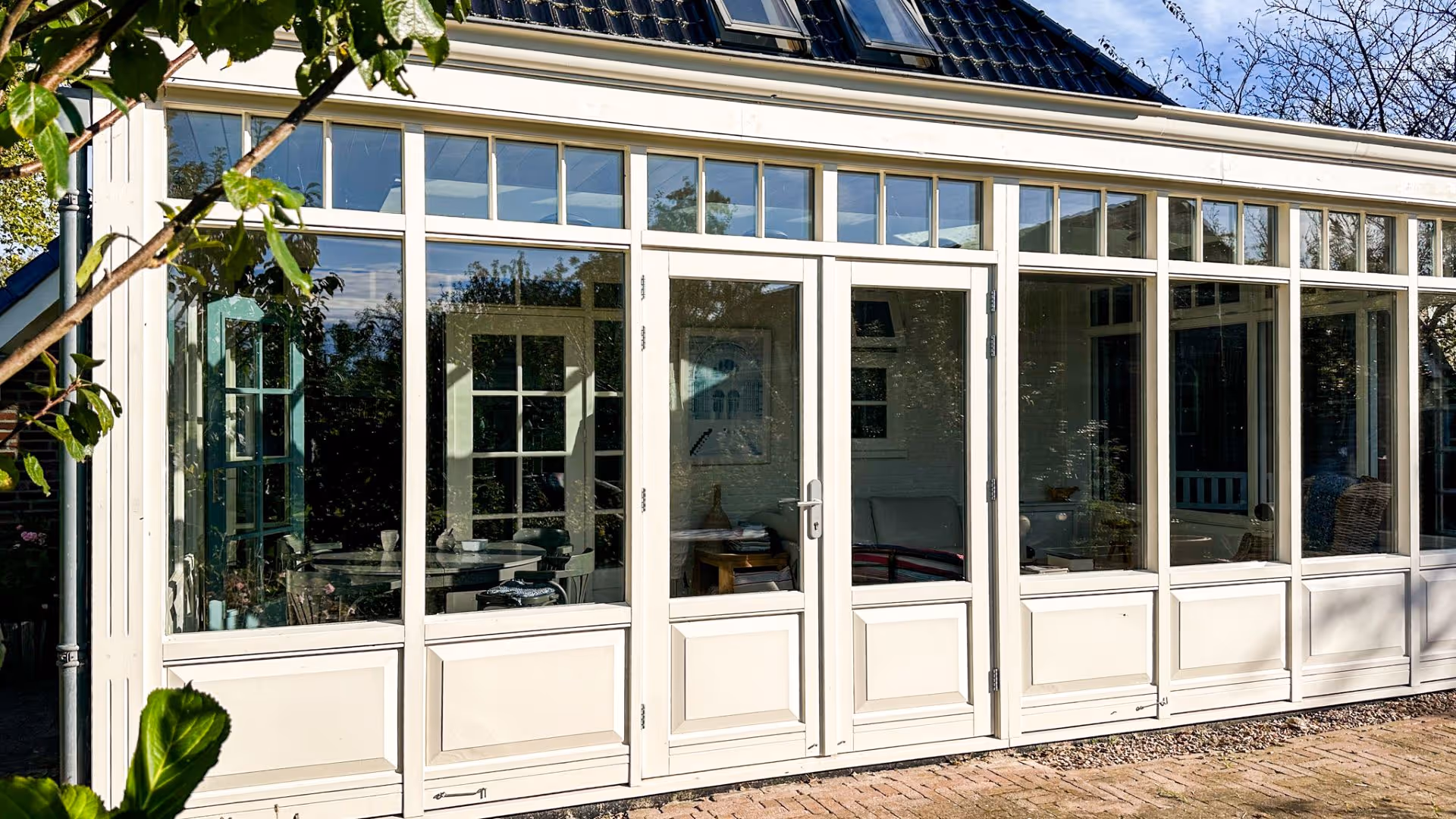 Glazen aanbouw met lichtstraat, comfortabele zithoek en veel natuurlijk daglicht.