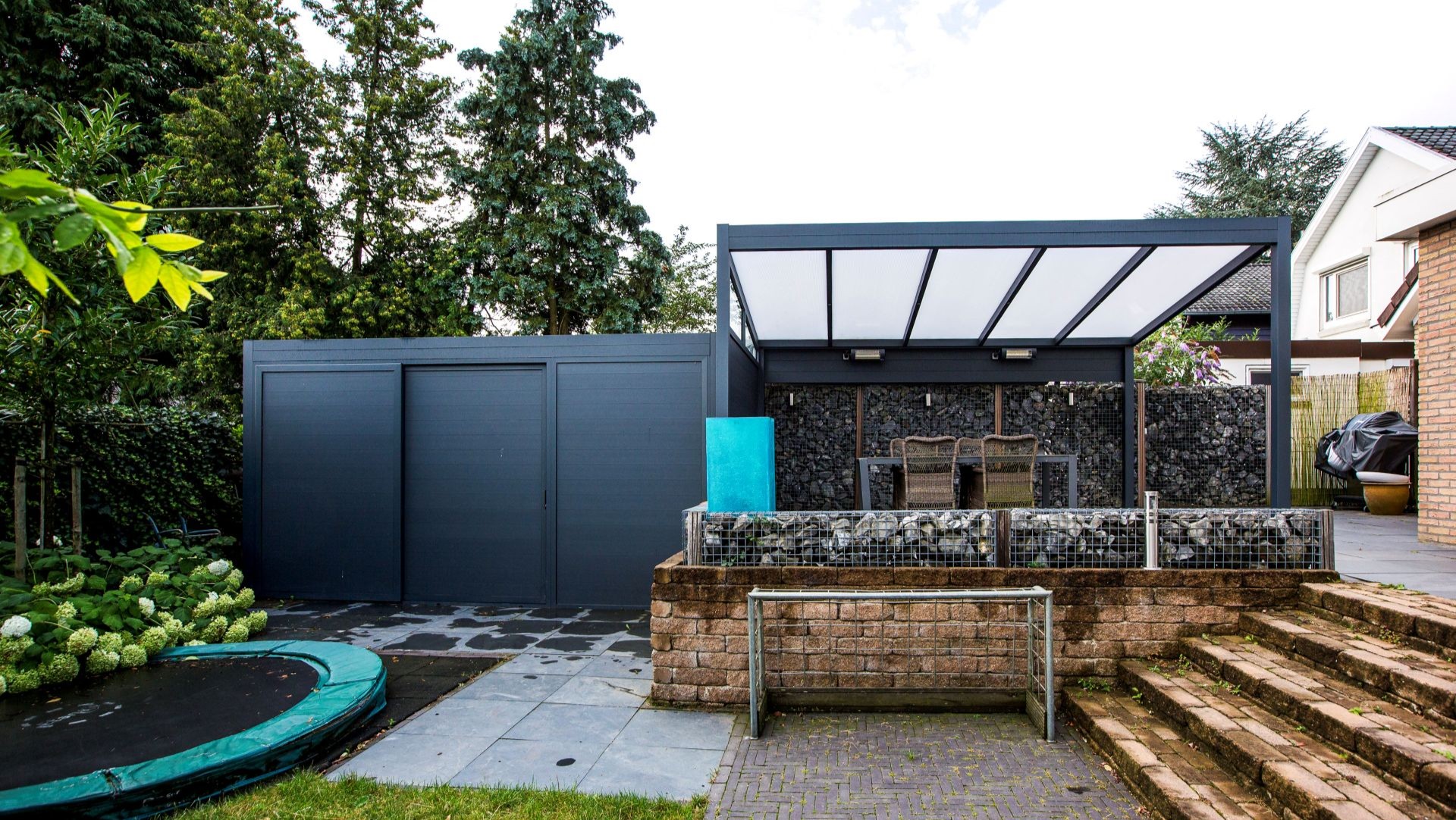 Strakke terrasoverkapping van aluminium met geïntegreerde berging en moderne tuin