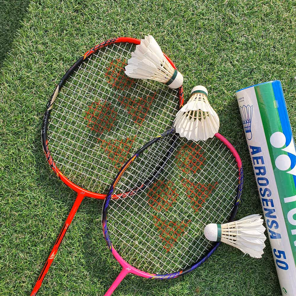 badminton rackets and shuttlecocks on grass