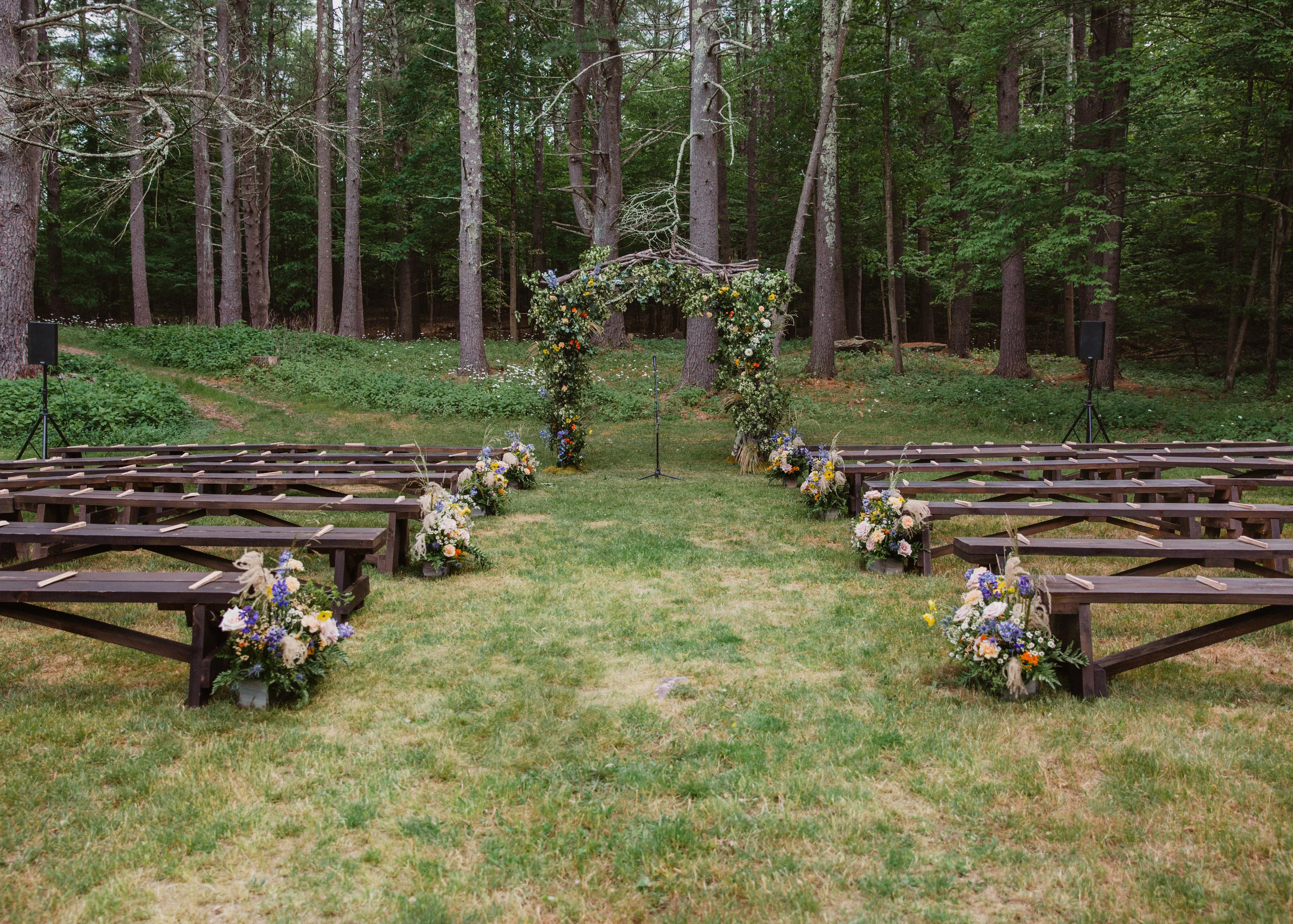 Colorful wildflower wedding arch and aisle florals at Glen Falls House