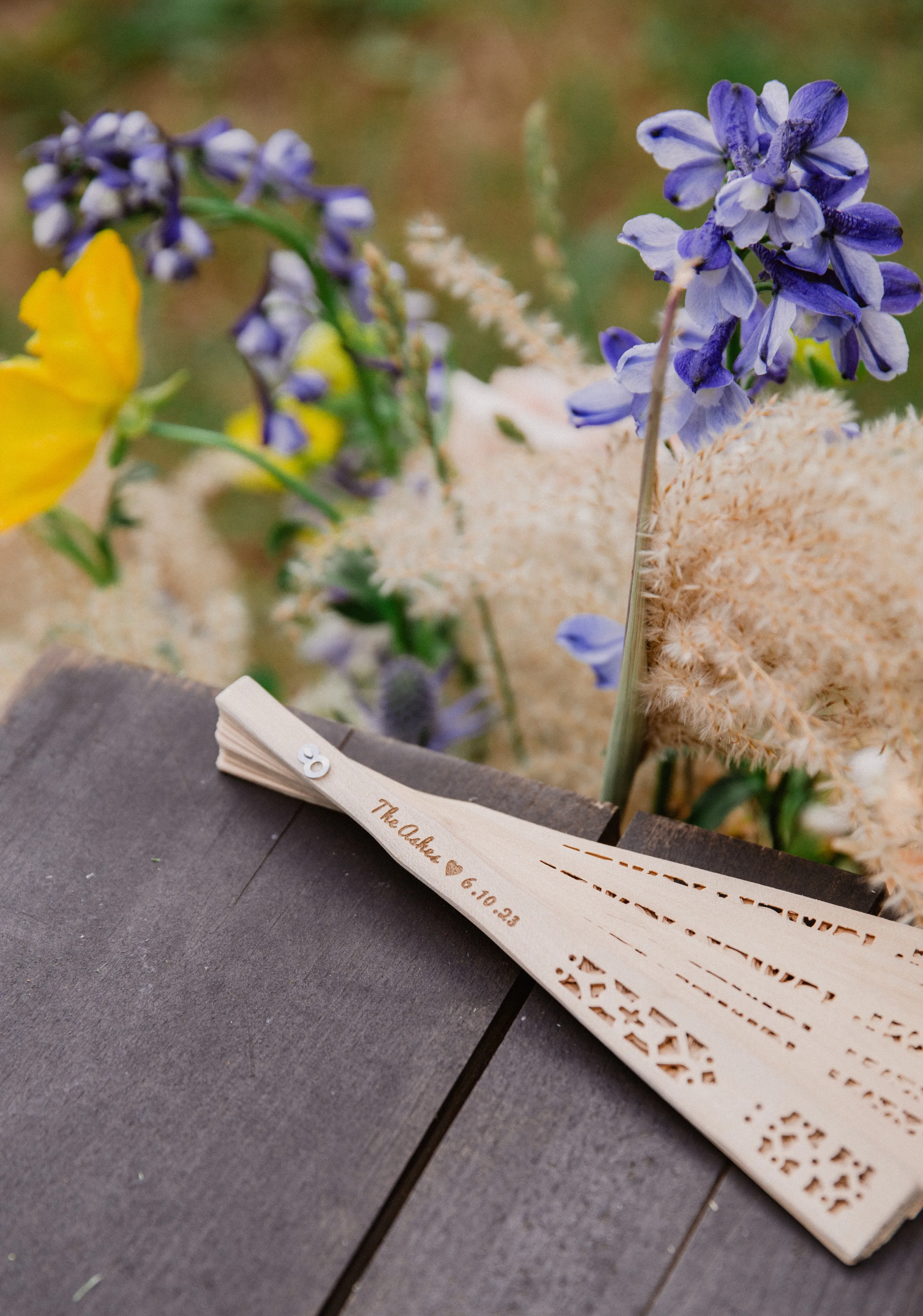 Ceremony detail of a paper fan and wildflower arrangement at Glen Falls House