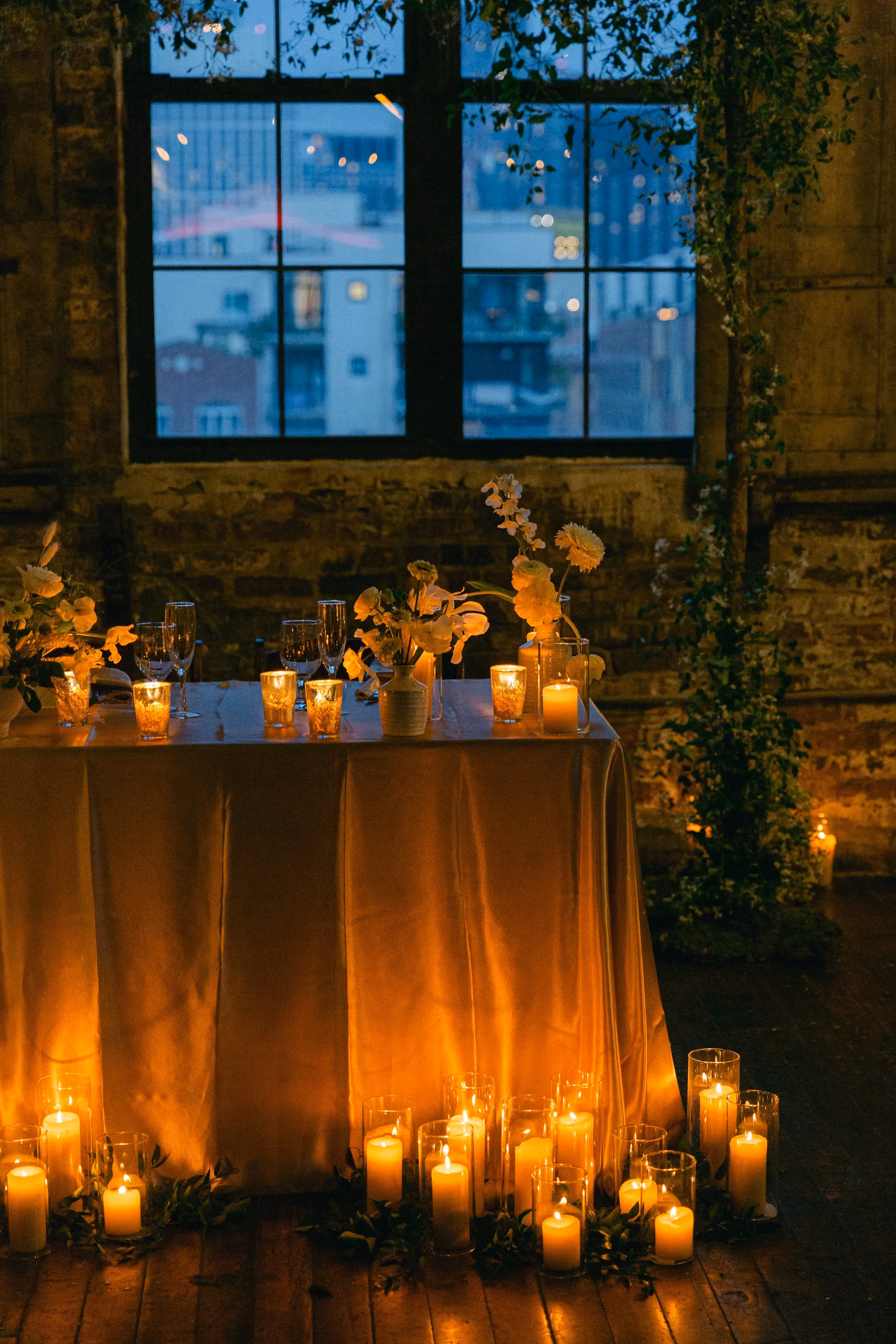 Greenpoint Loft Wedding Reception Sweetheart table with candles and flowers