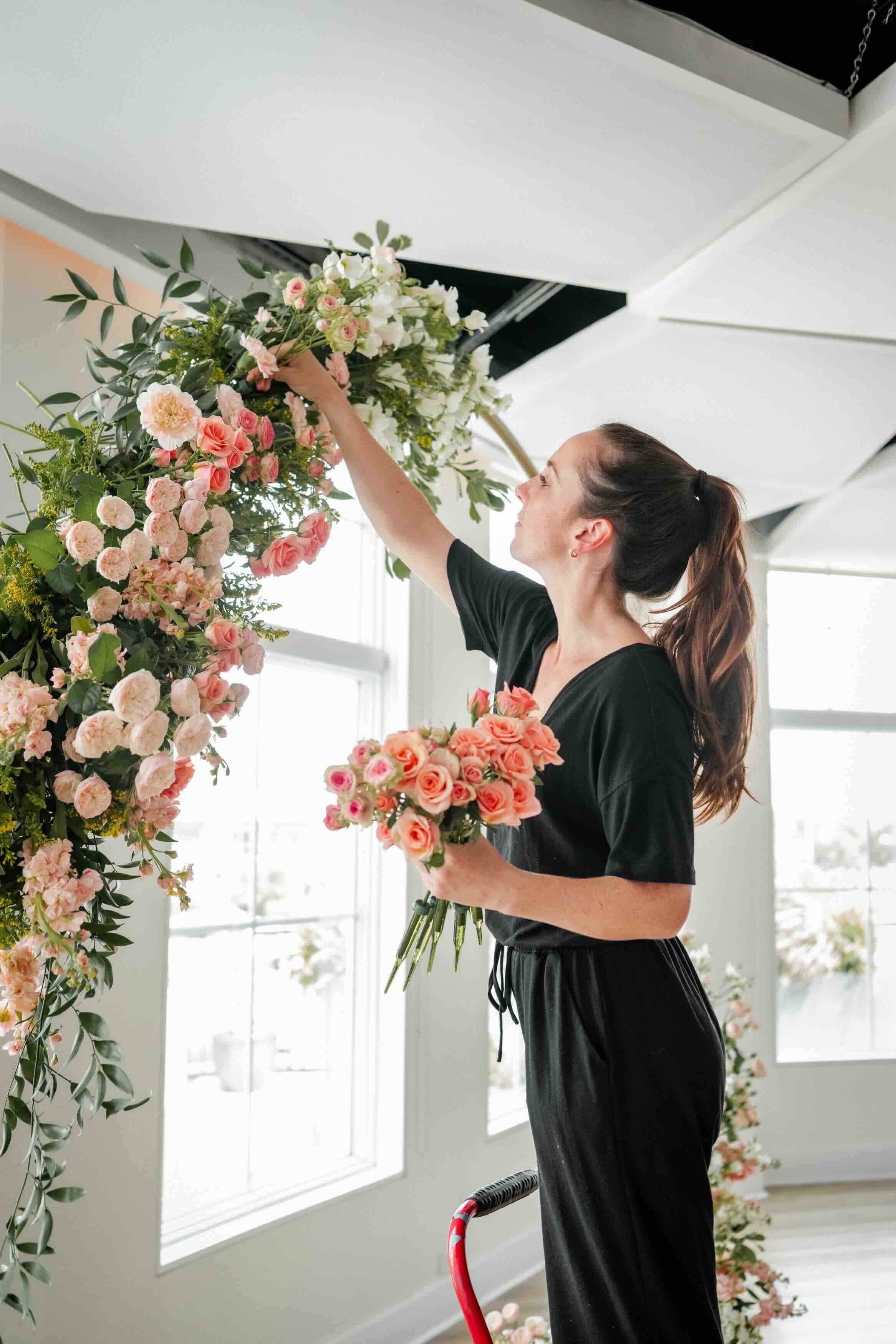 Floral designer working on a flower arch