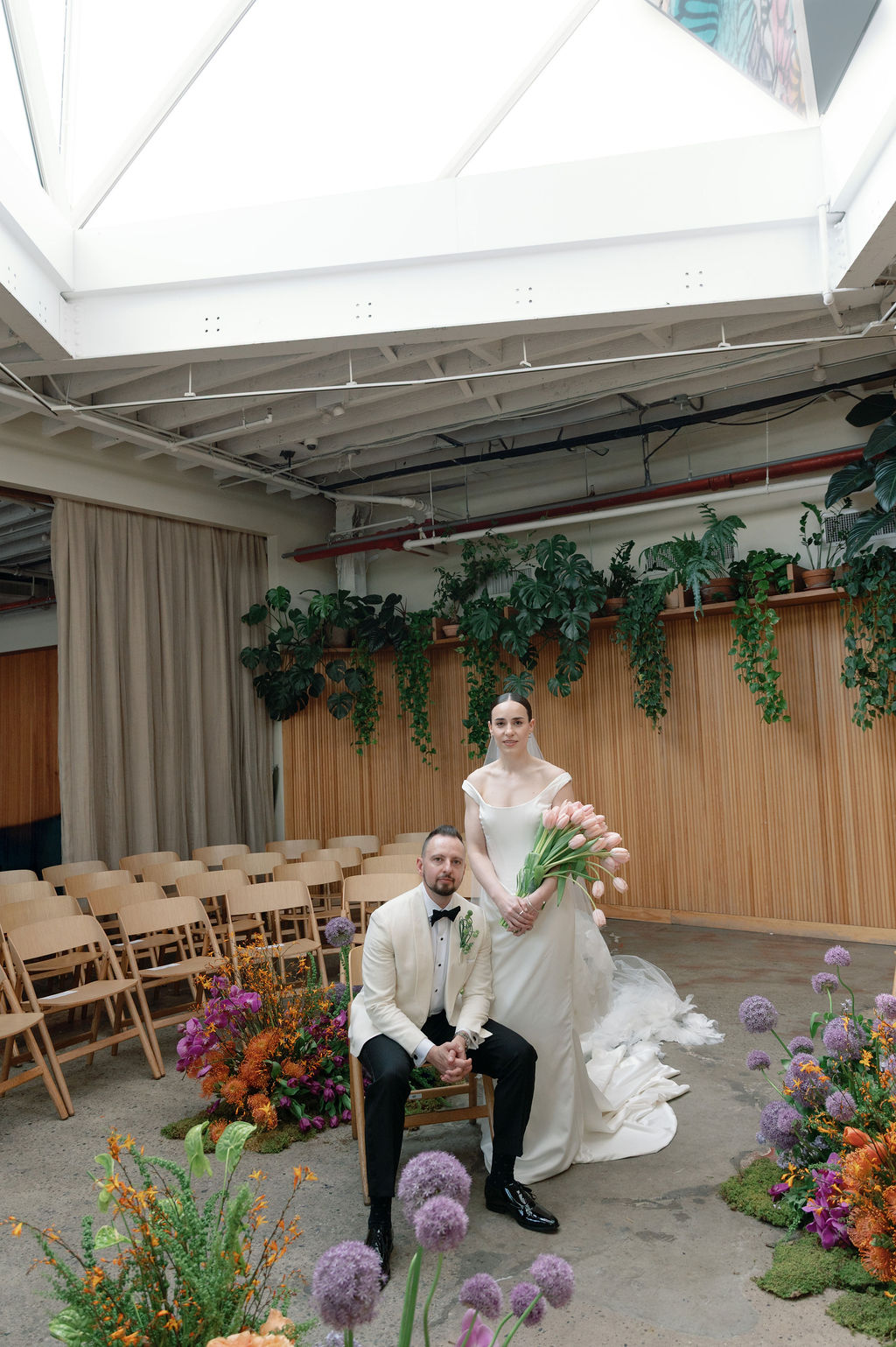 Bride and groom exchanging vows in front of a floral installation at Rule of Thirds