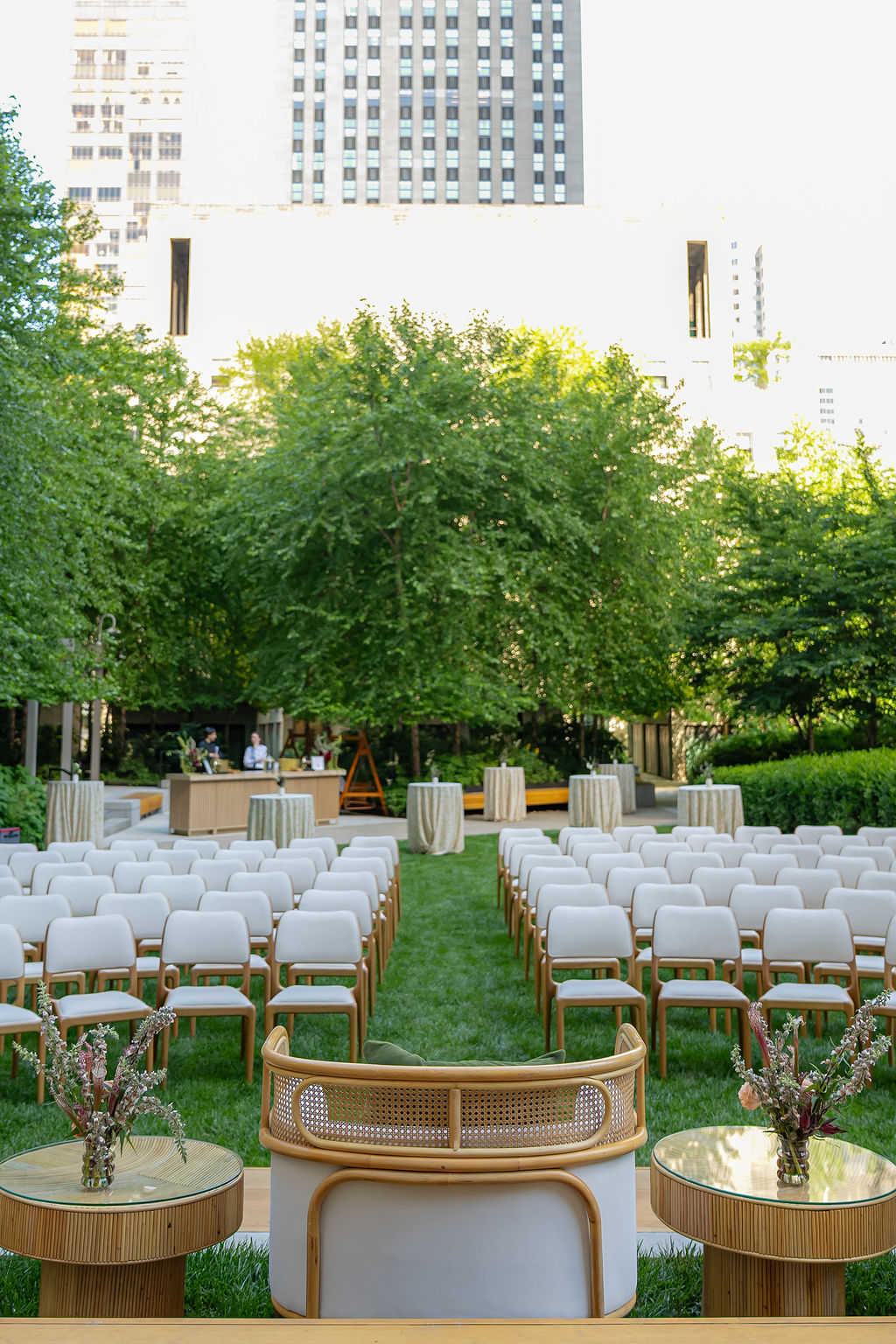 Rows of white chairs set up for an outdoor corporate event with city skyline and greenery