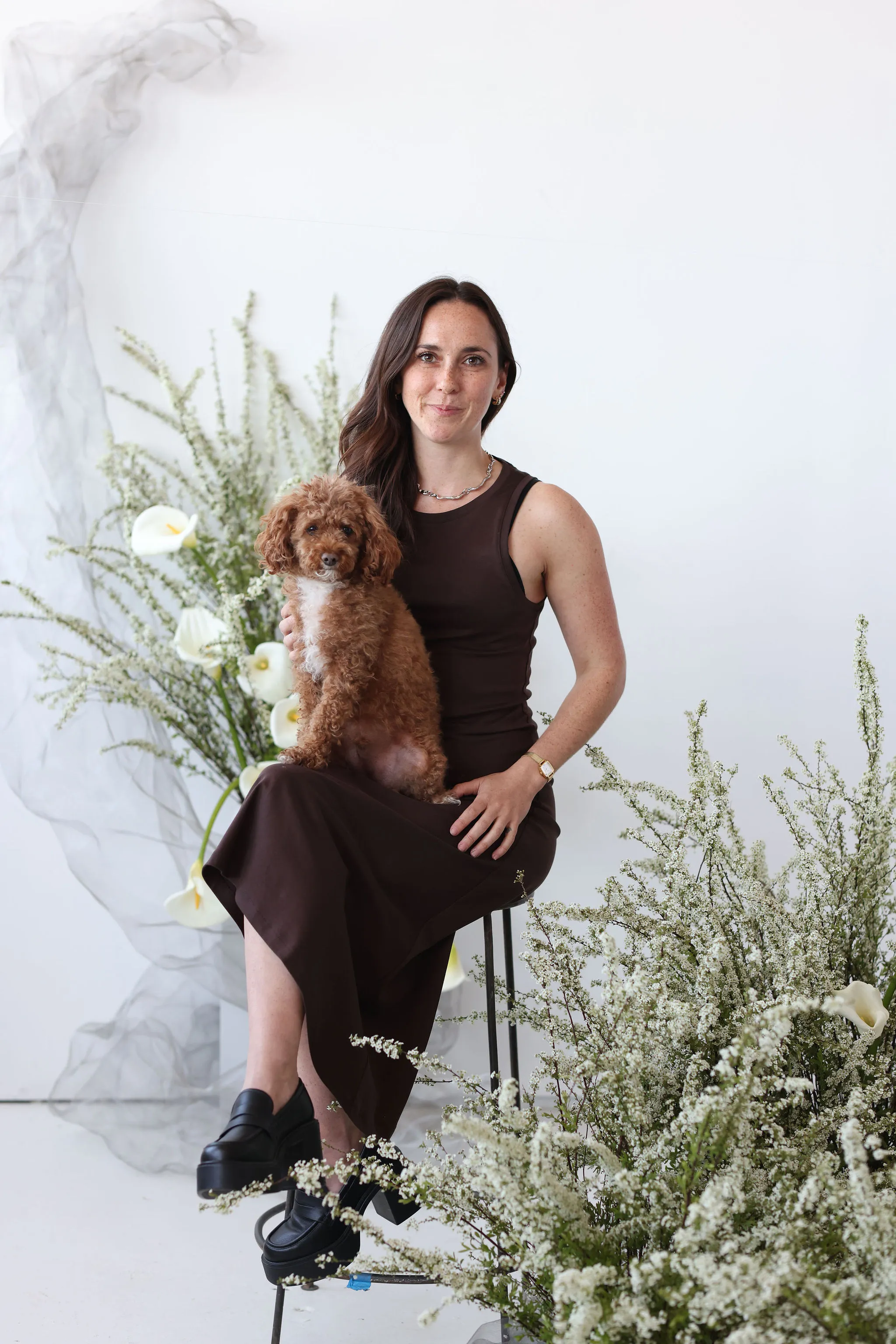 A portrait of a florist with a dog on her lap