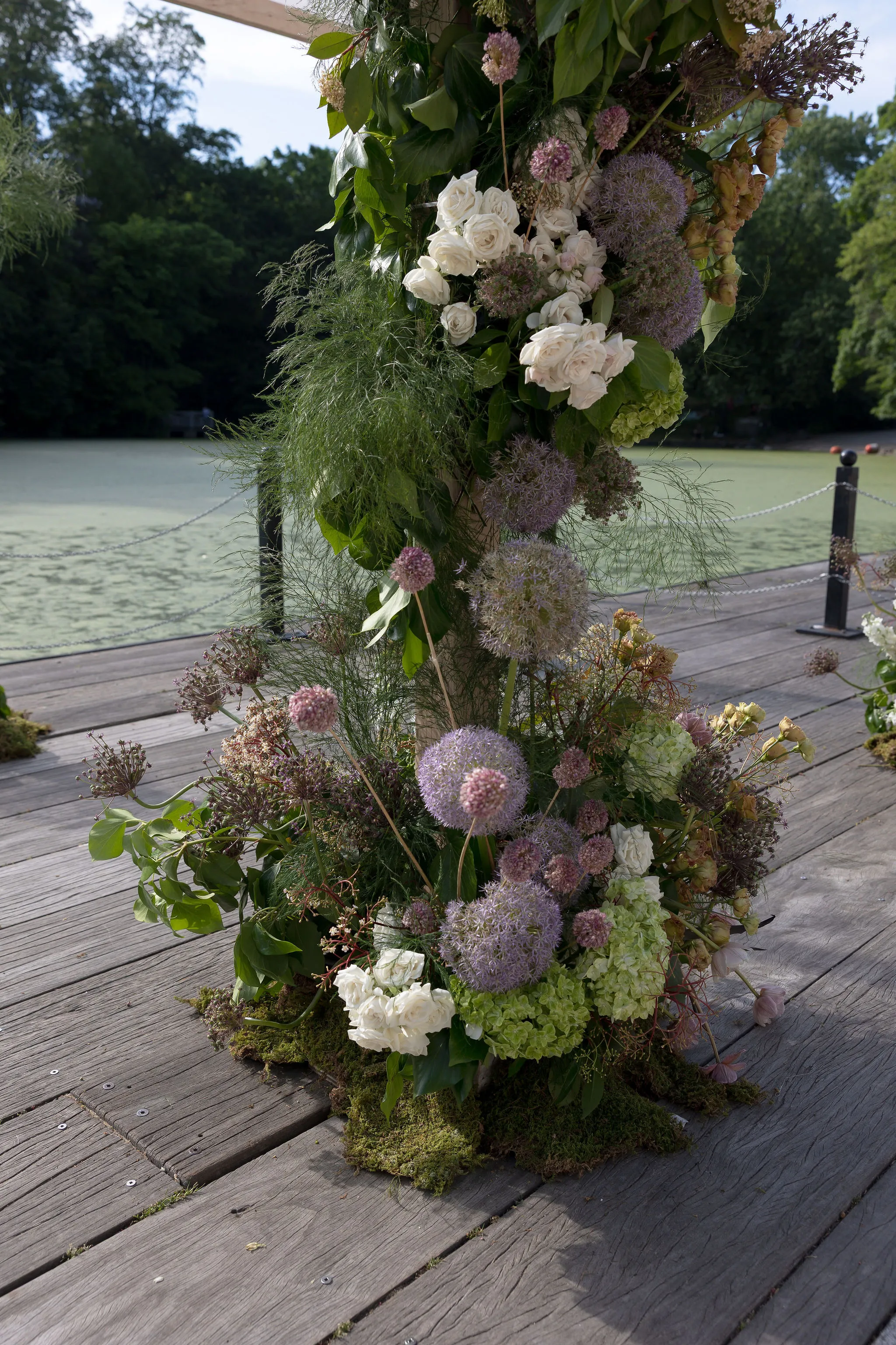 Detail of dried pink ranunculus, allium, and queen anne's lace woven into the ceremony arch.