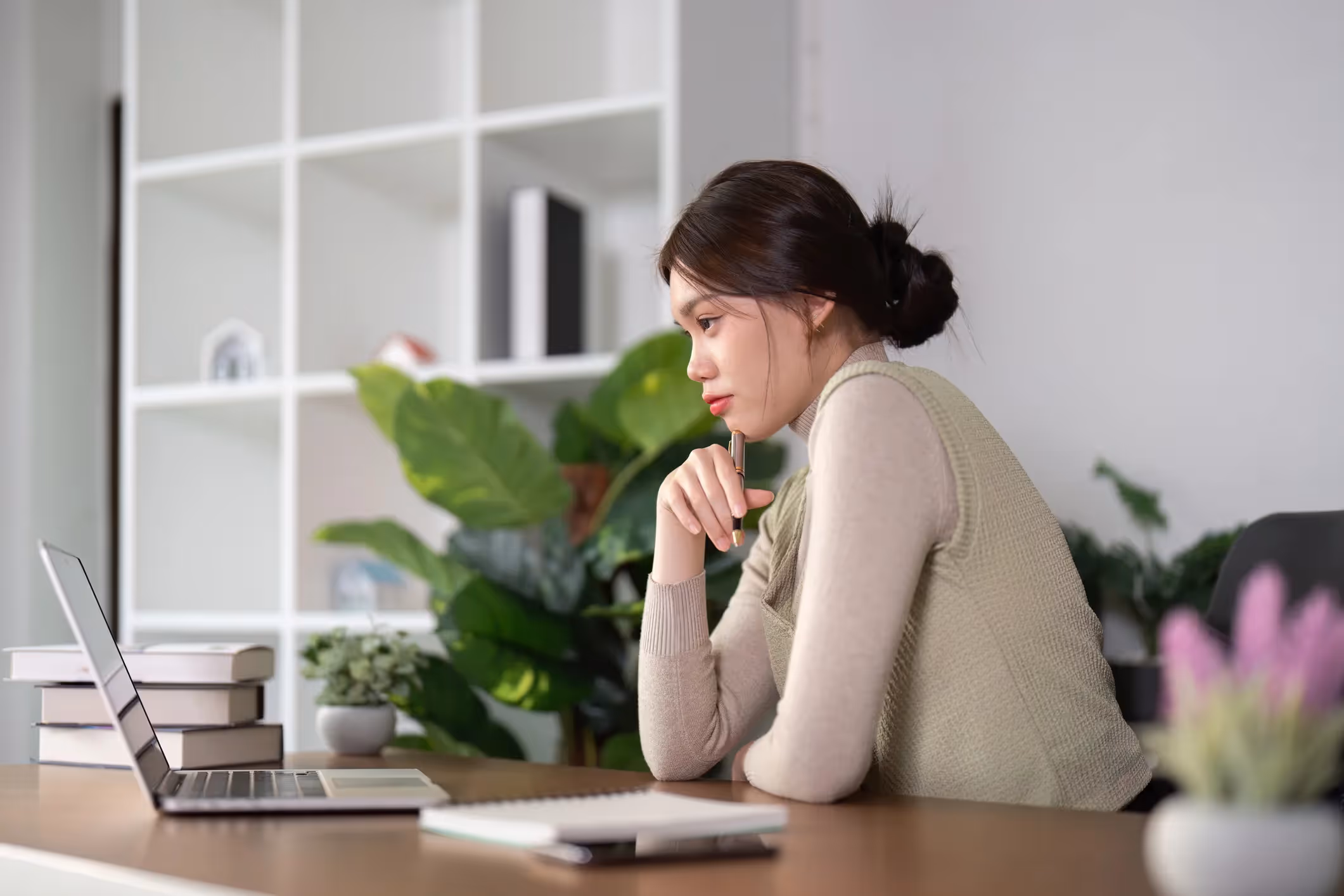 A woman sitting at her desk works at her computer. 