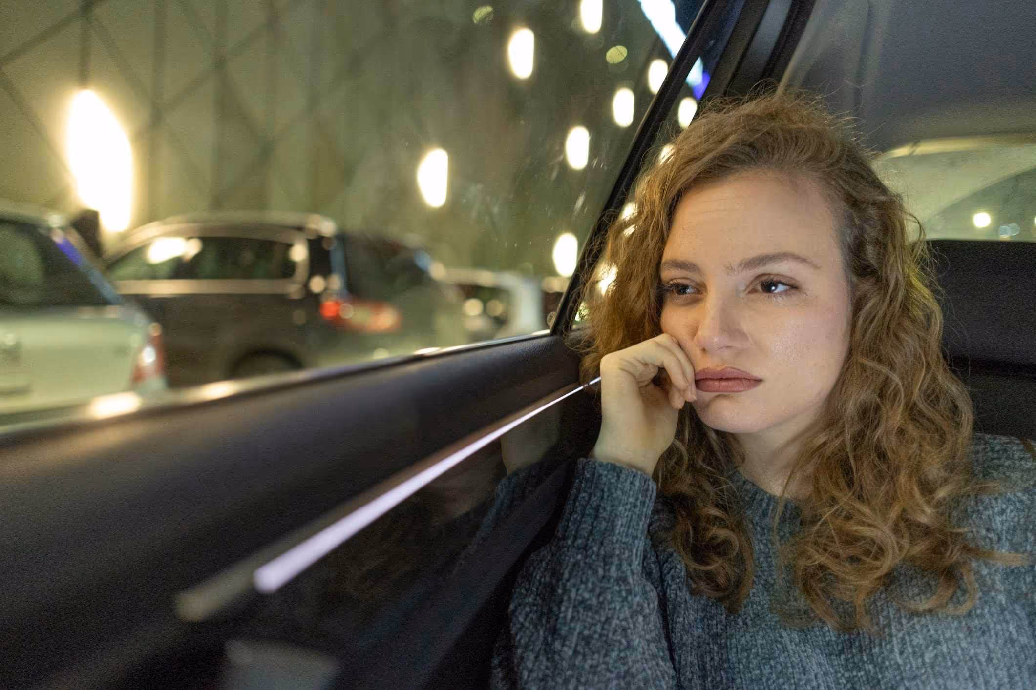 A survivor riding in a car considers contacting an Alabama Uber sexual assault lawyer.