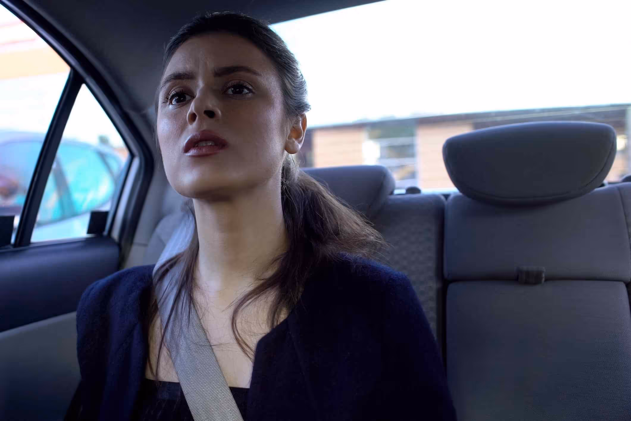 Anxious woman in a rideshare car, representing the role of a Los Angeles Uber sexual assault attorney.