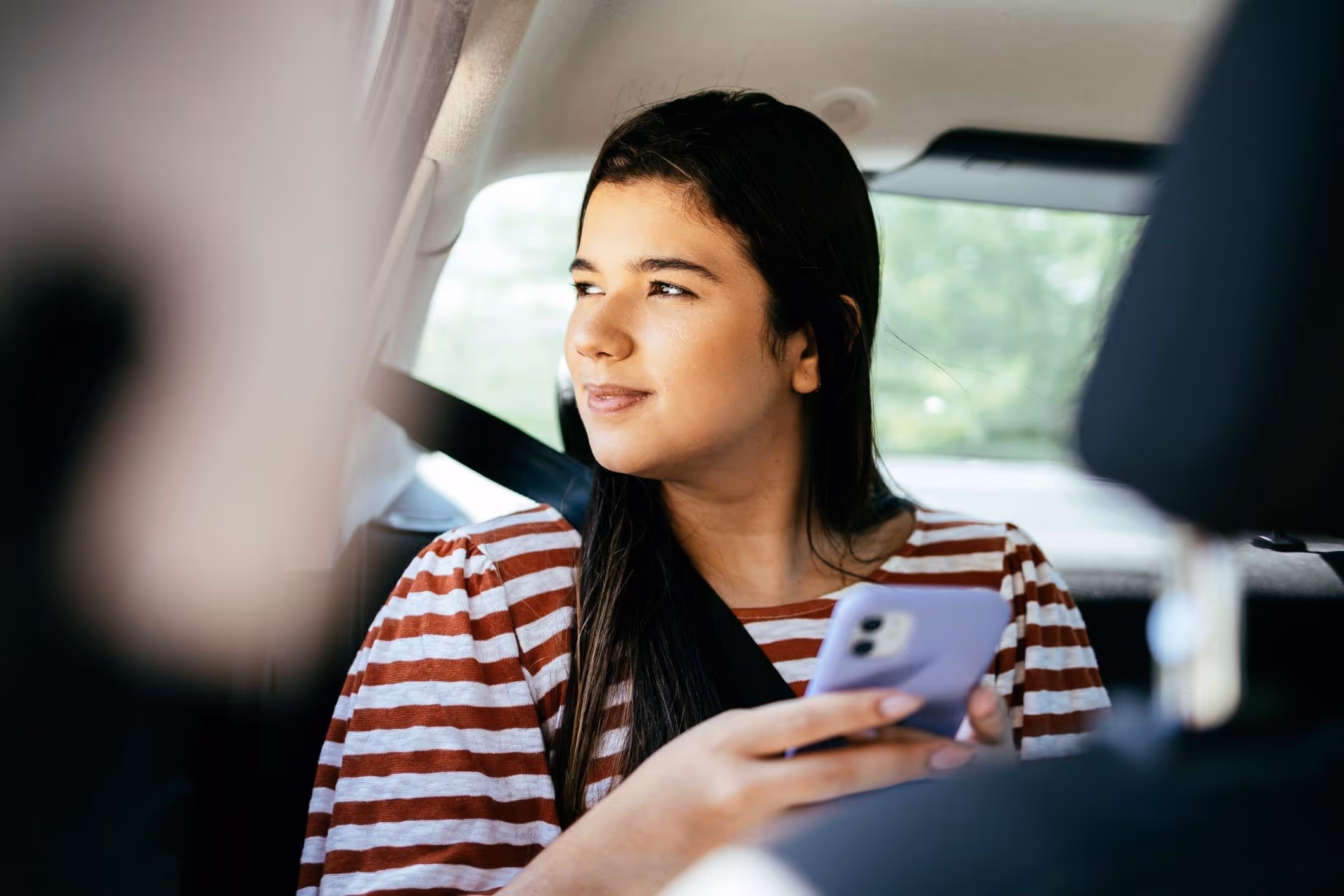 Young woman in back seat of car, representing Las Vegas Uber sexual assault attorney.