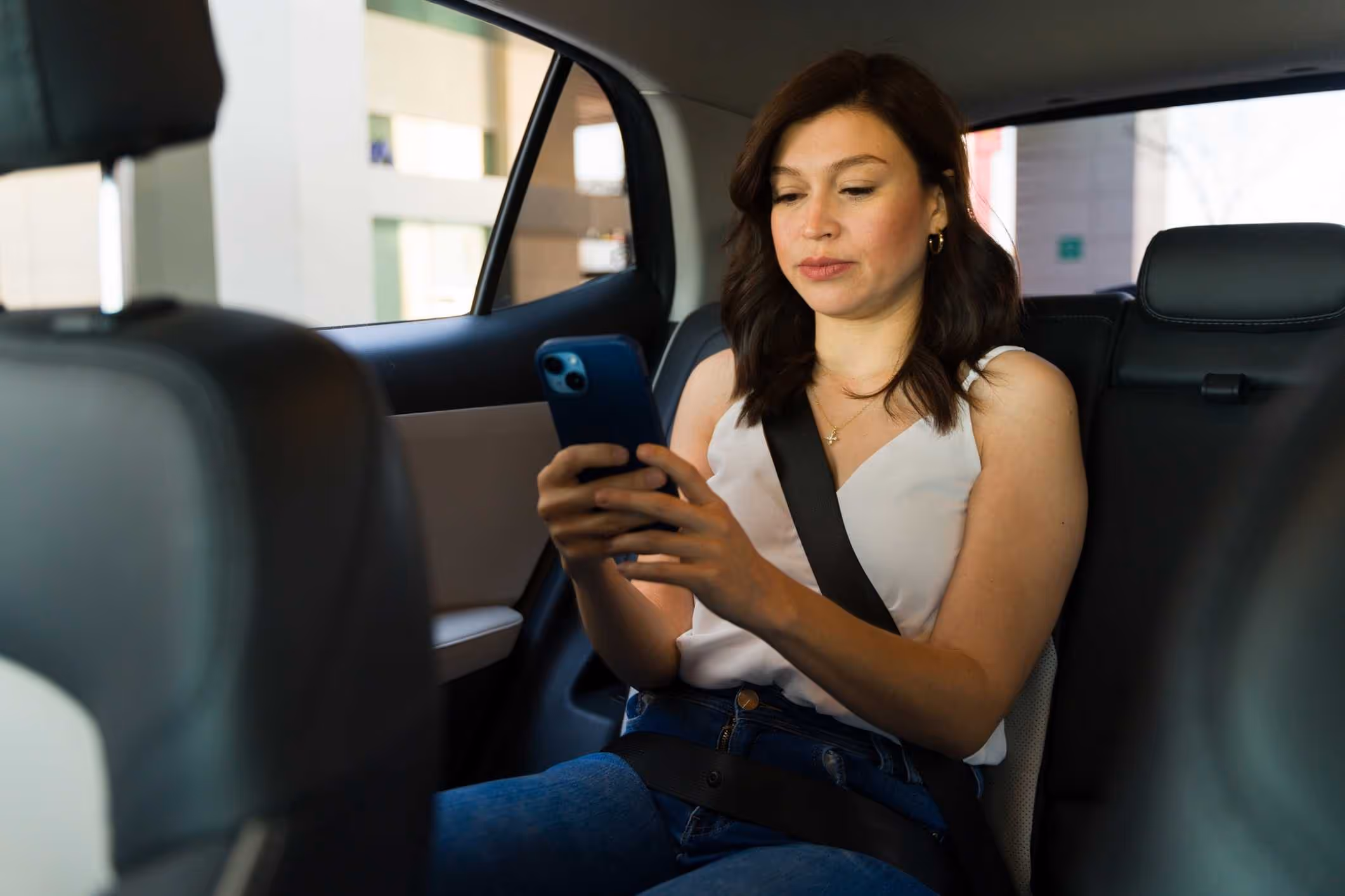 Passenger in car using phone, representing Houston Uber sexual assault attorney.