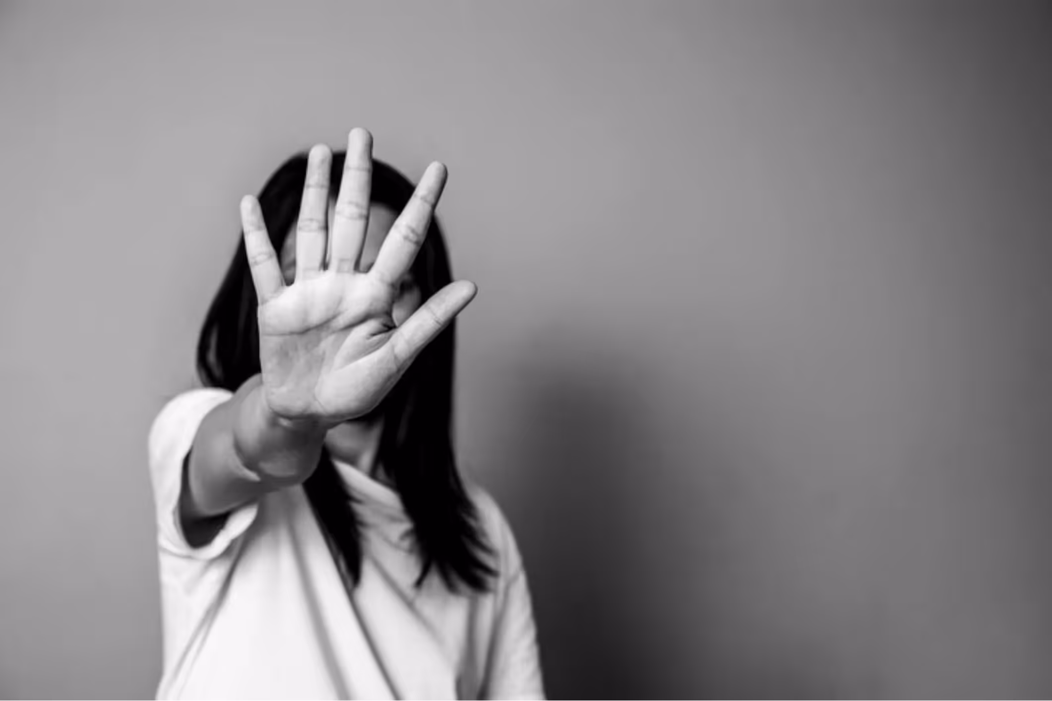 A woman stands solemnly with her hand in front of her face. She is coming to terms with the fact that she may need a San Francisco institutional sexual abuse lawyer.