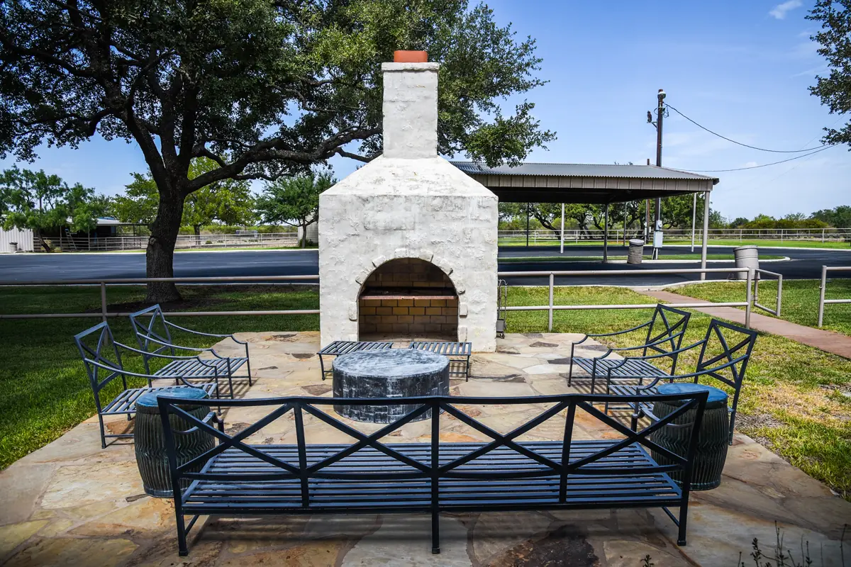 Image of an outdoor seating area in front of a stone oven