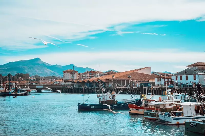 The fishing port of Saint-Jean-de-Luz with mountains in the background.