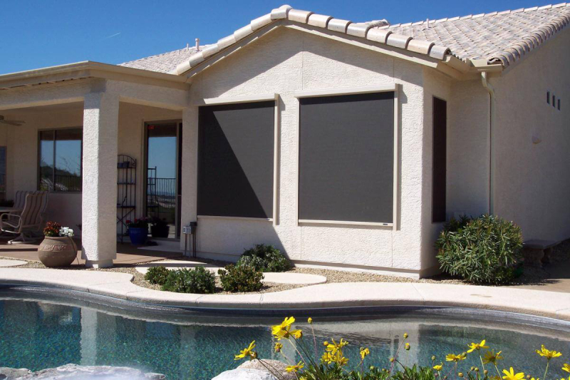 Exterior patio shades on house near pool.