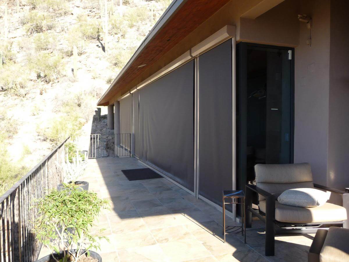 Outdoor patio with dark roll-up shades