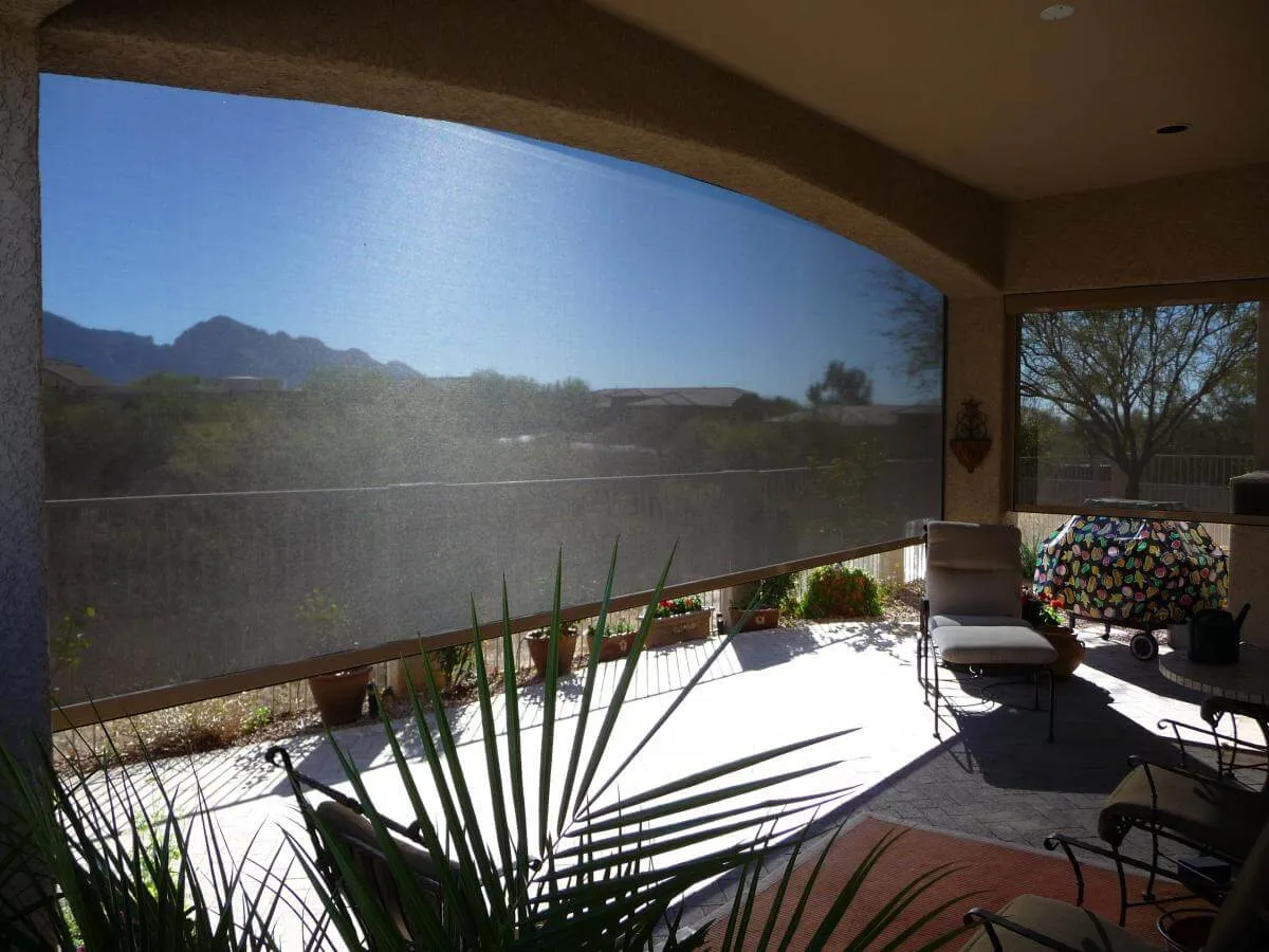 Outdoor patio with mesh shade panel blocking sunlight.
