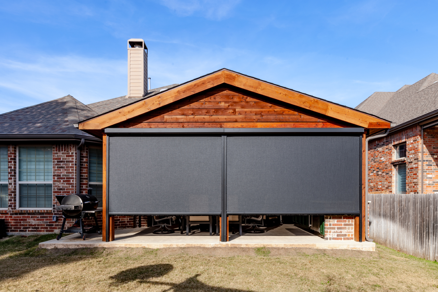 Outdoor patio with retractable screens on a suburban house.