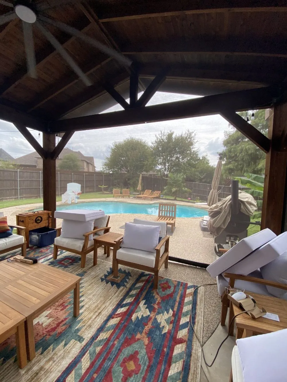Outdoor patio with furniture and pool in backyard.