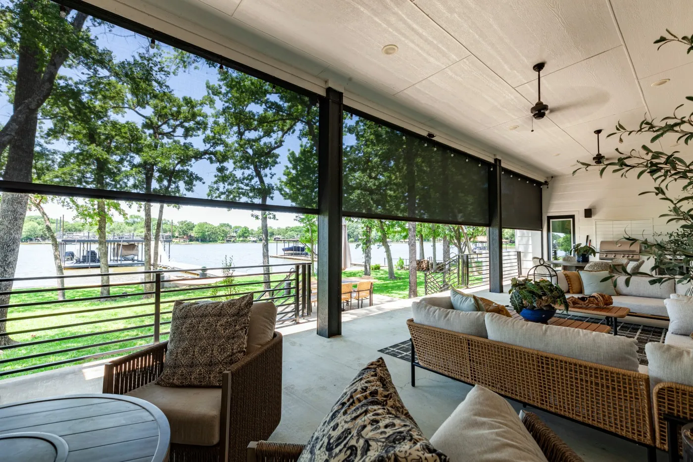 Outdoor entertainment area with rolling shutters overlooking the lake.