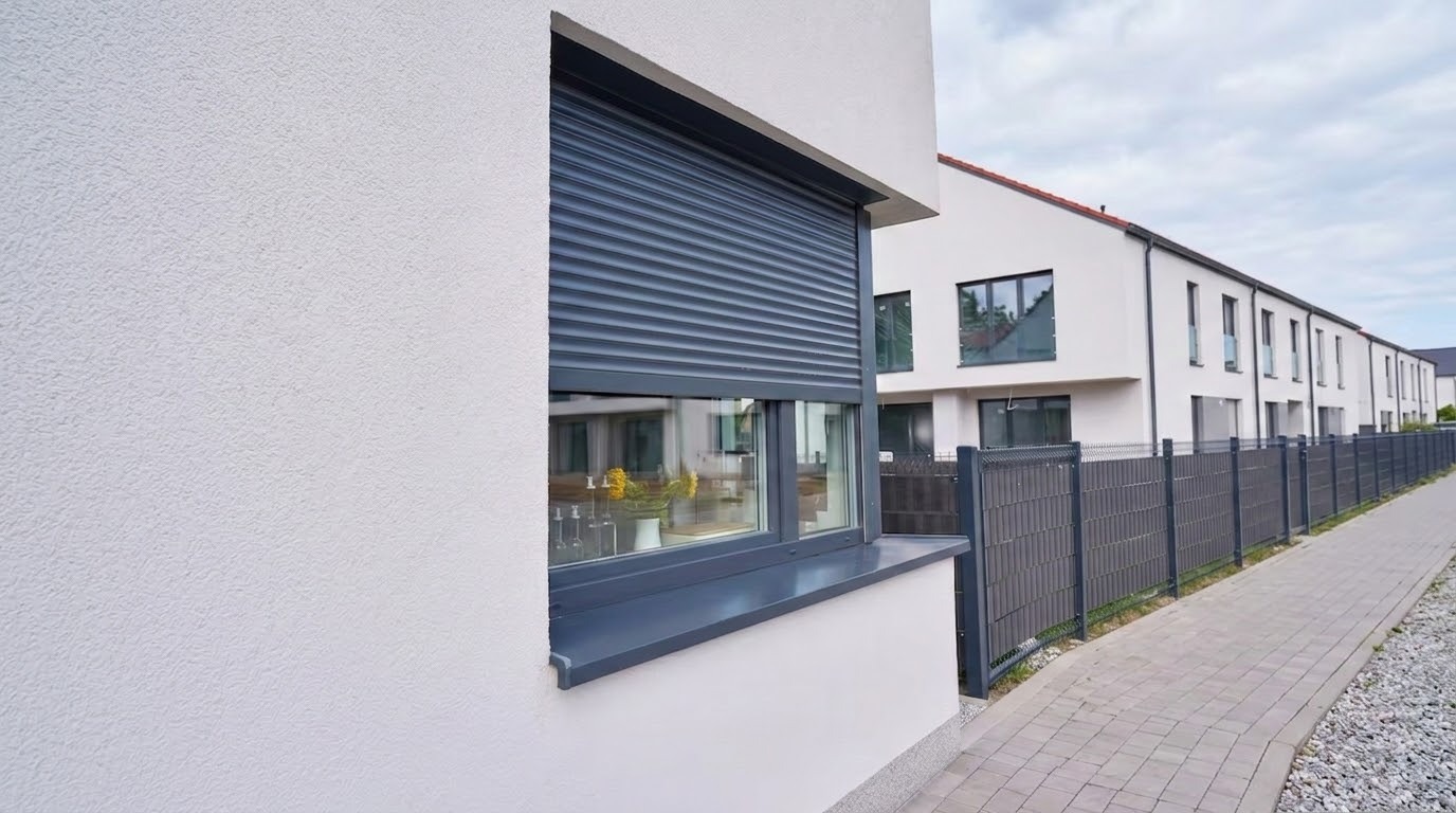 Exterior window fitted with a partially lowered rolling shutter on a modern home.