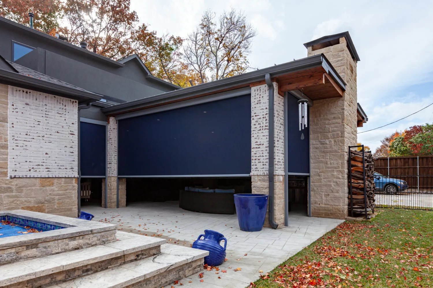 Retractable exterior screens enclosing a covered backyard patio.