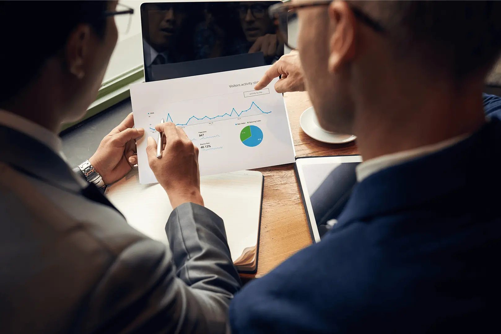 Executivos analisando dados em tela com gráficos e contratos imobiliários, representando gestão estratégica e eficiência corporativa.