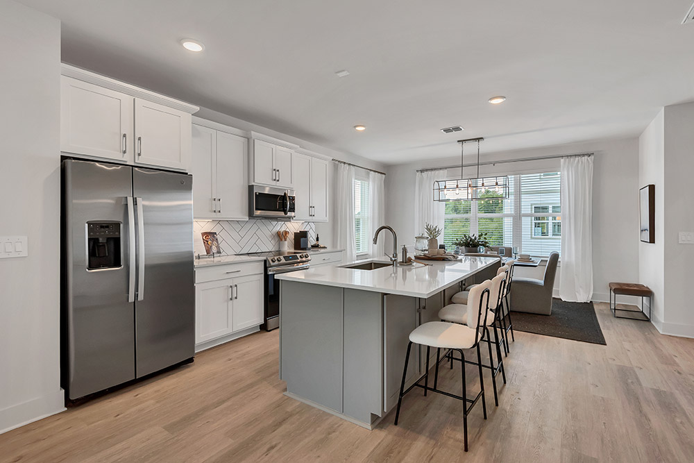 Interior photo of a kitchen with an island in the middle of it.