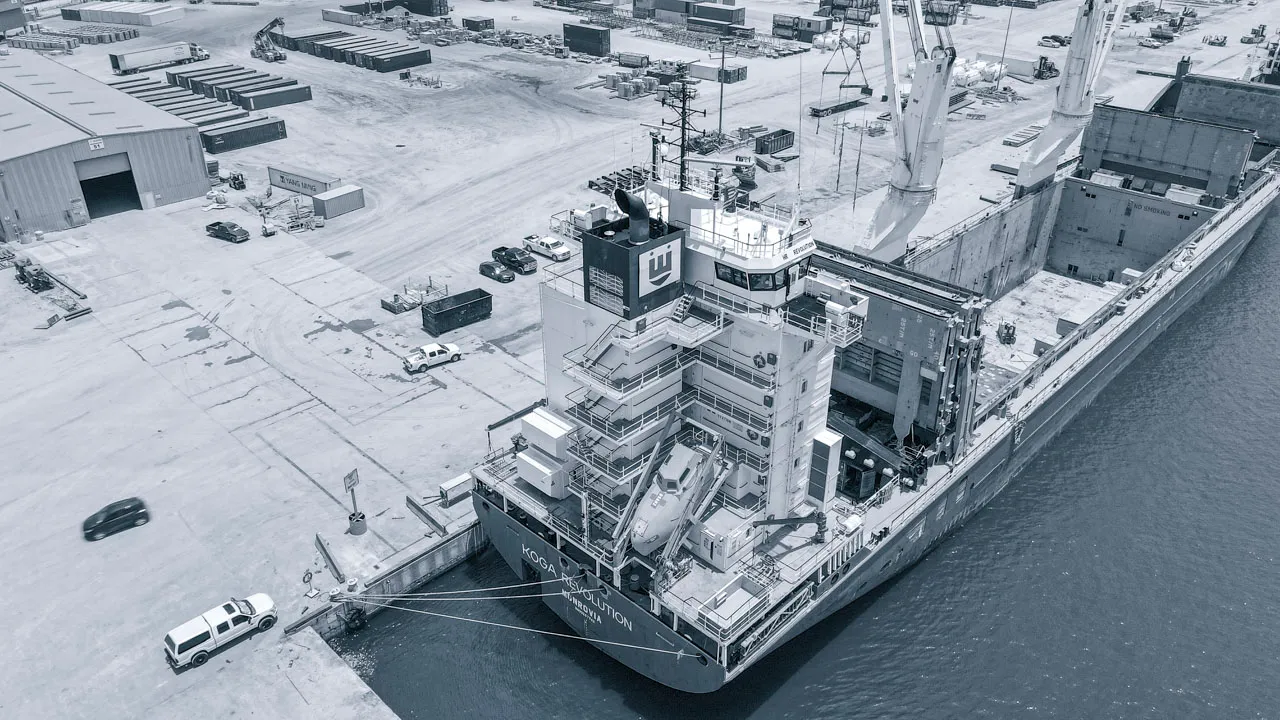 Aerial close-up of the KOGA Revolution ship’s superstructure and deck during cargo loading, showcasing professional maritime transport capabilities.