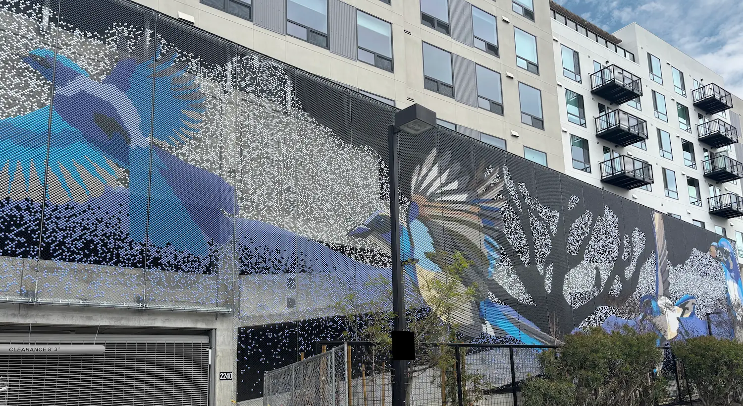 AVE Santa Clara building, an eight-story residential mid-rise with over three hundred homes including a parking garaga, down the street from Levis’s Stadium. The open parking façade is covered with a Dedots screens, an artwork created in collaboration with a local artists Roan Victor. In her words: “It makes me smile to know that I get to show you these giant, larger than life scrub jays hanging out around the silhouette of a grand Coast Live Oak tree. I always relish these opportunities to share something about our California native flora and fauna.”