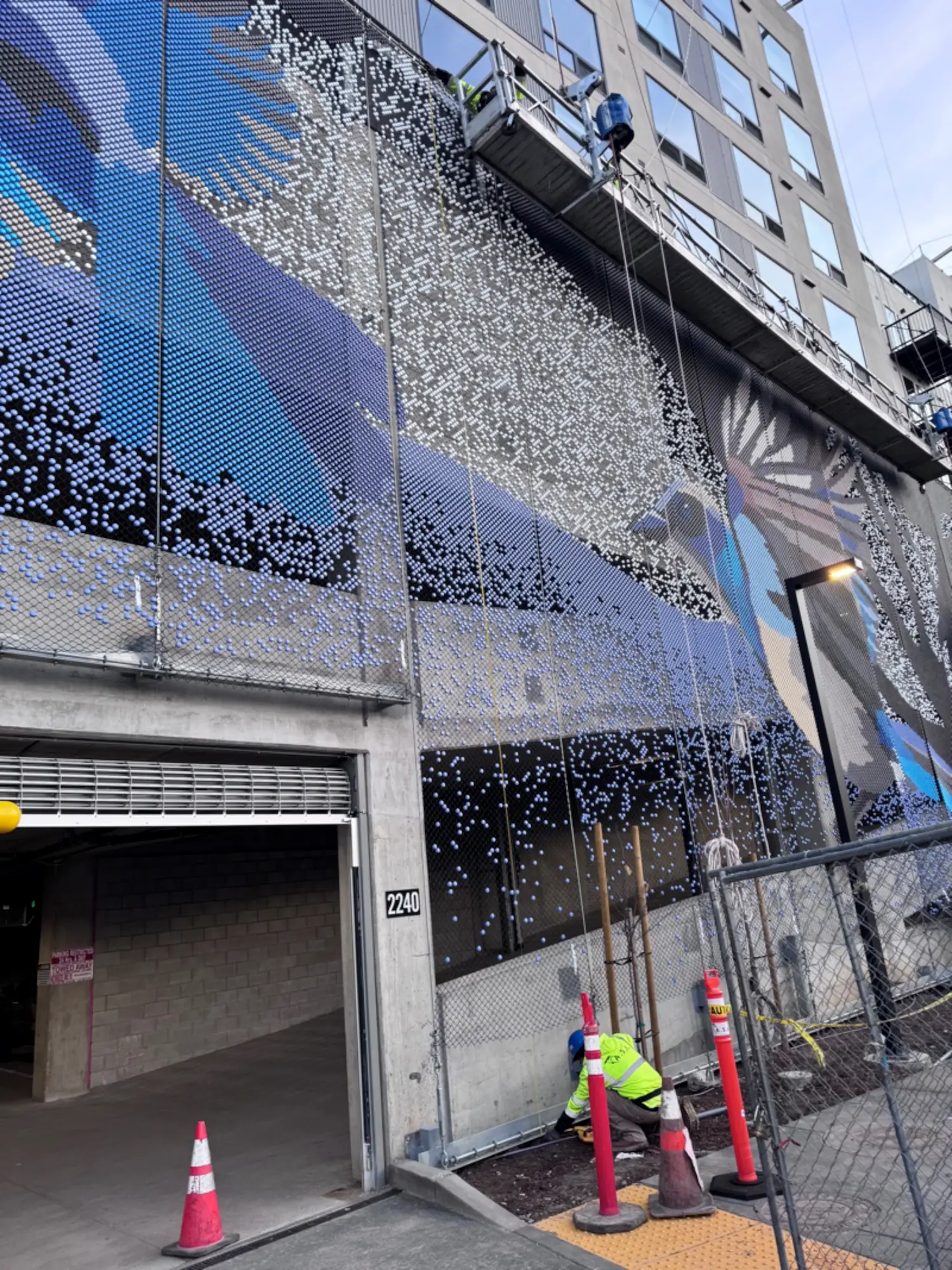 AVE Santa Clara building, an eight-story residential mid-rise with over three hundred homes including a parking garaga, down the street from Levis’s Stadium. The open parking façade is covered with a Dedots screens, an artwork created in collaboration with a local artists Roan Victor. In her words: “It makes me smile to know that I get to show you these giant, larger than life scrub jays hanging out around the silhouette of a grand Coast Live Oak tree. I always relish these opportunities to share something about our California native flora and fauna.”