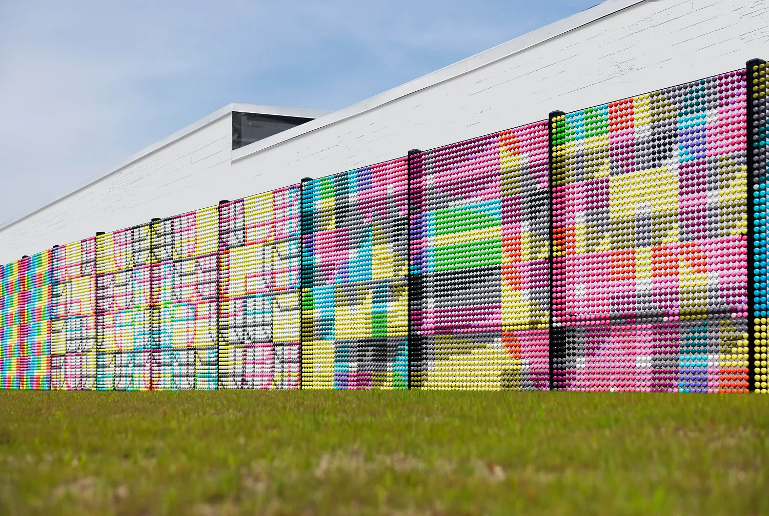 “Dotted Sequences” uses over 56,500 3D recycled plastic dots, spanning 1,500 square feet of fence and transforms complex genetic science into bold, accessible public art.