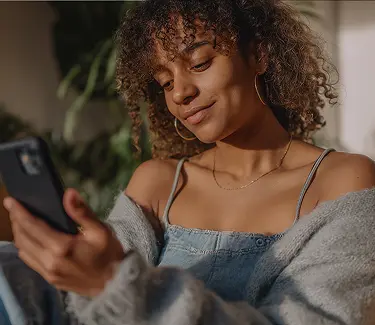 Mujer concentrada siguiendo una rutina de ejercicios de Fisify desde su móvil, representando la combinación de tecnología, fisioterapia y motivación para mejorar la salud y el rendimiento físico desde casa.