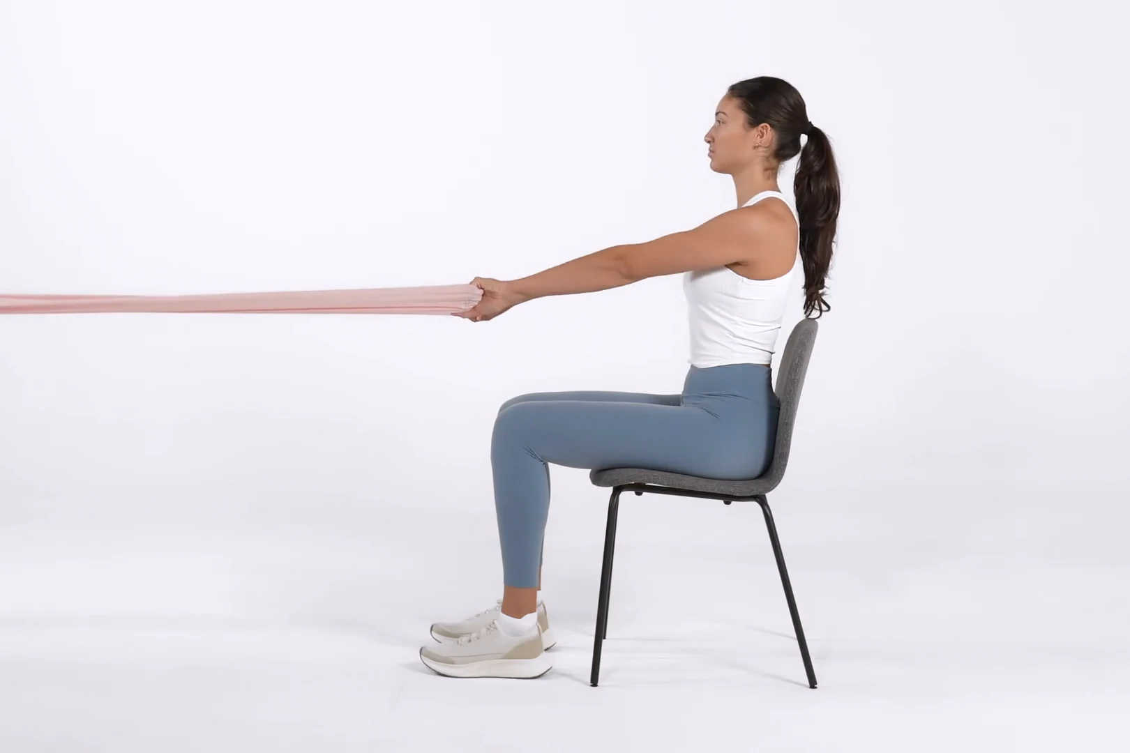 Remo con banda elástica sentada en una silla