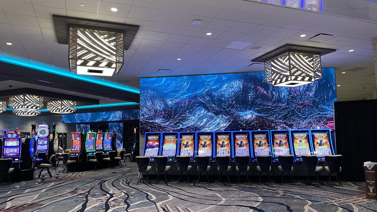 A wall-sized LED display on the Yaamava&rsquo; gaming floor, behind a bank of machines