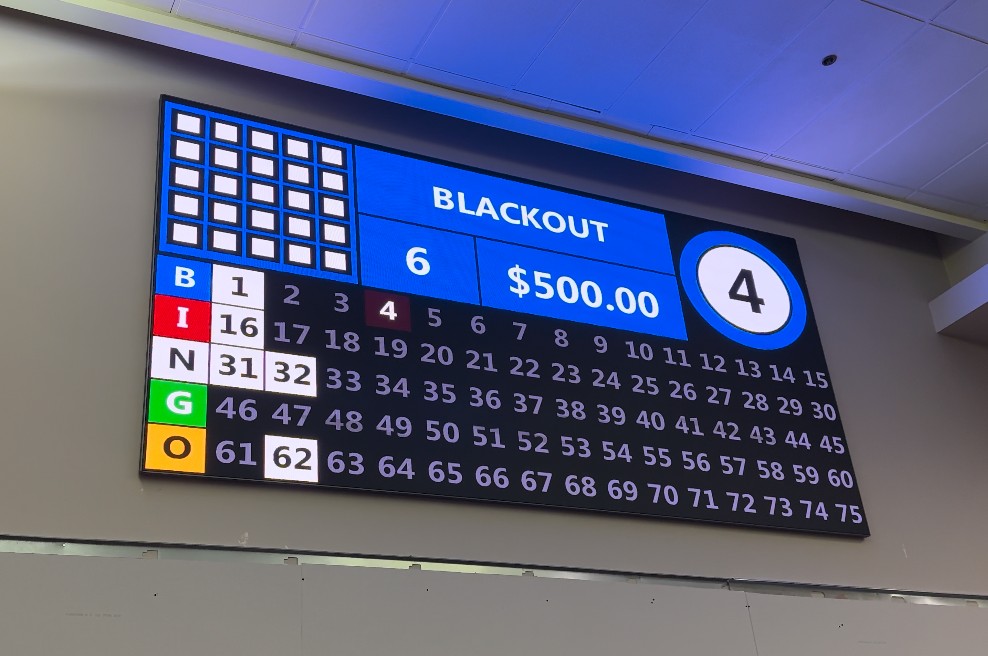 LUCI bingo wall interface in operation — blackout pattern, called numbers highlighted, prize display, and the current call on screen