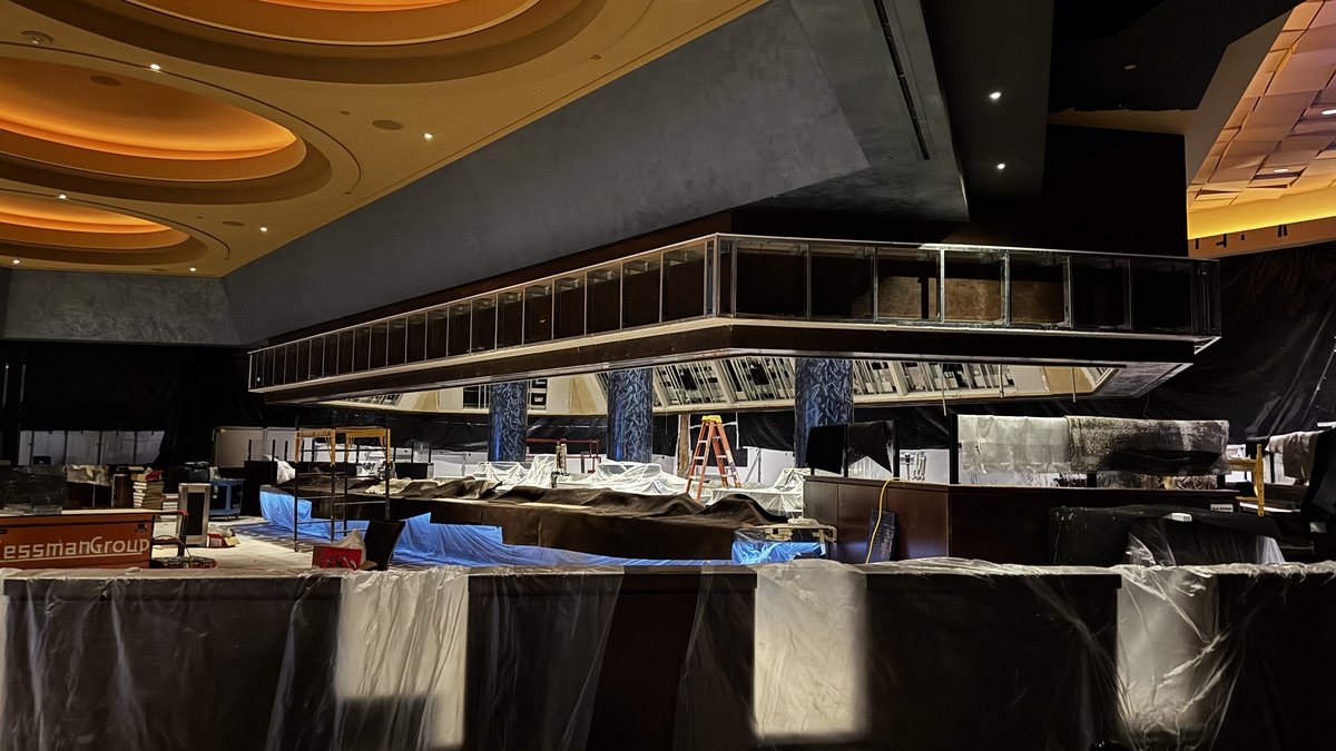 Skeletal metal framework for the sportsbook bar centerpiece suspended from the ceiling at Aliante, with the bar area below covered in protective plastic during construction
