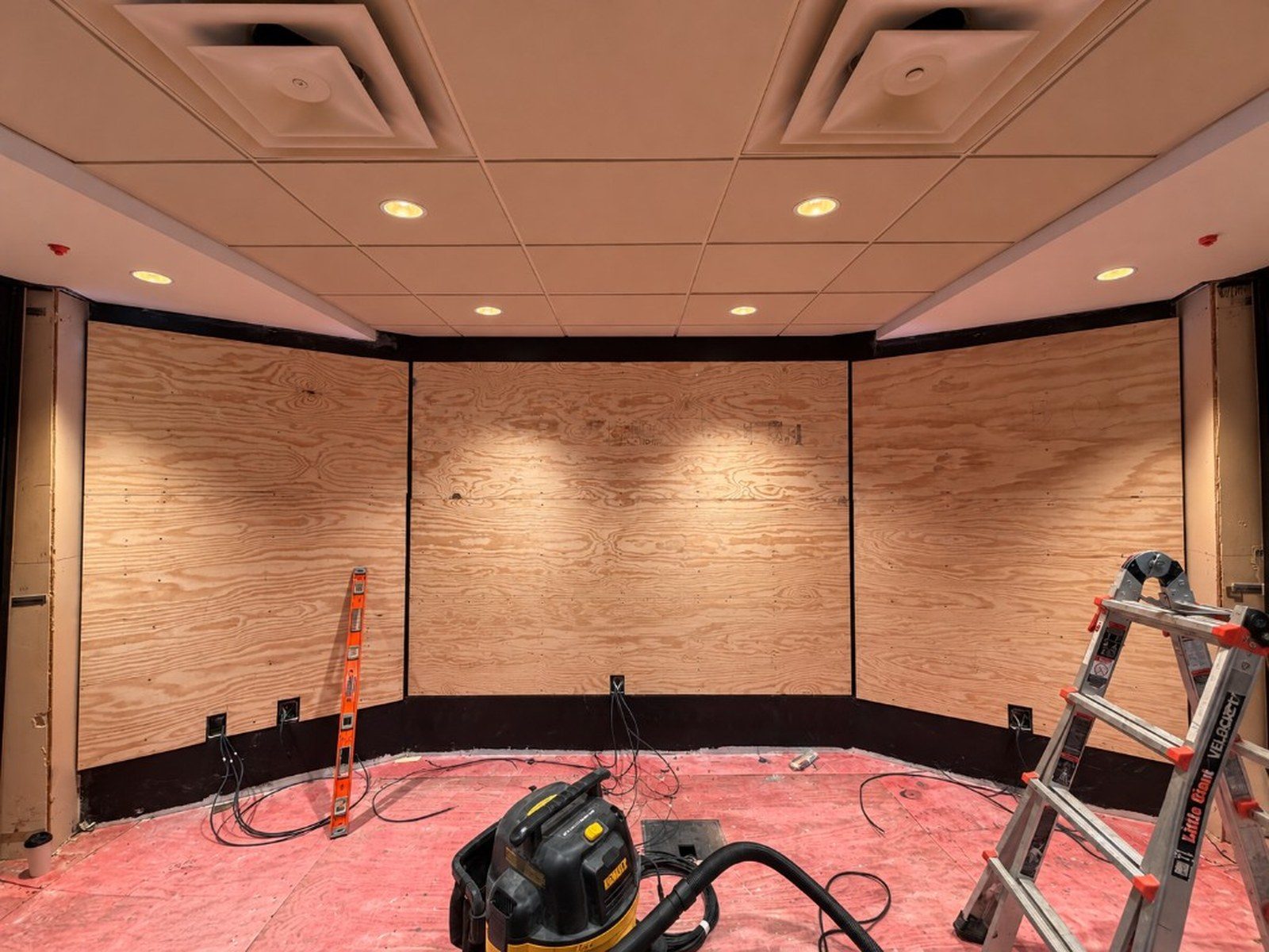 The three-plane Swigs LED wall during installation, with plywood backing and tools on the floor