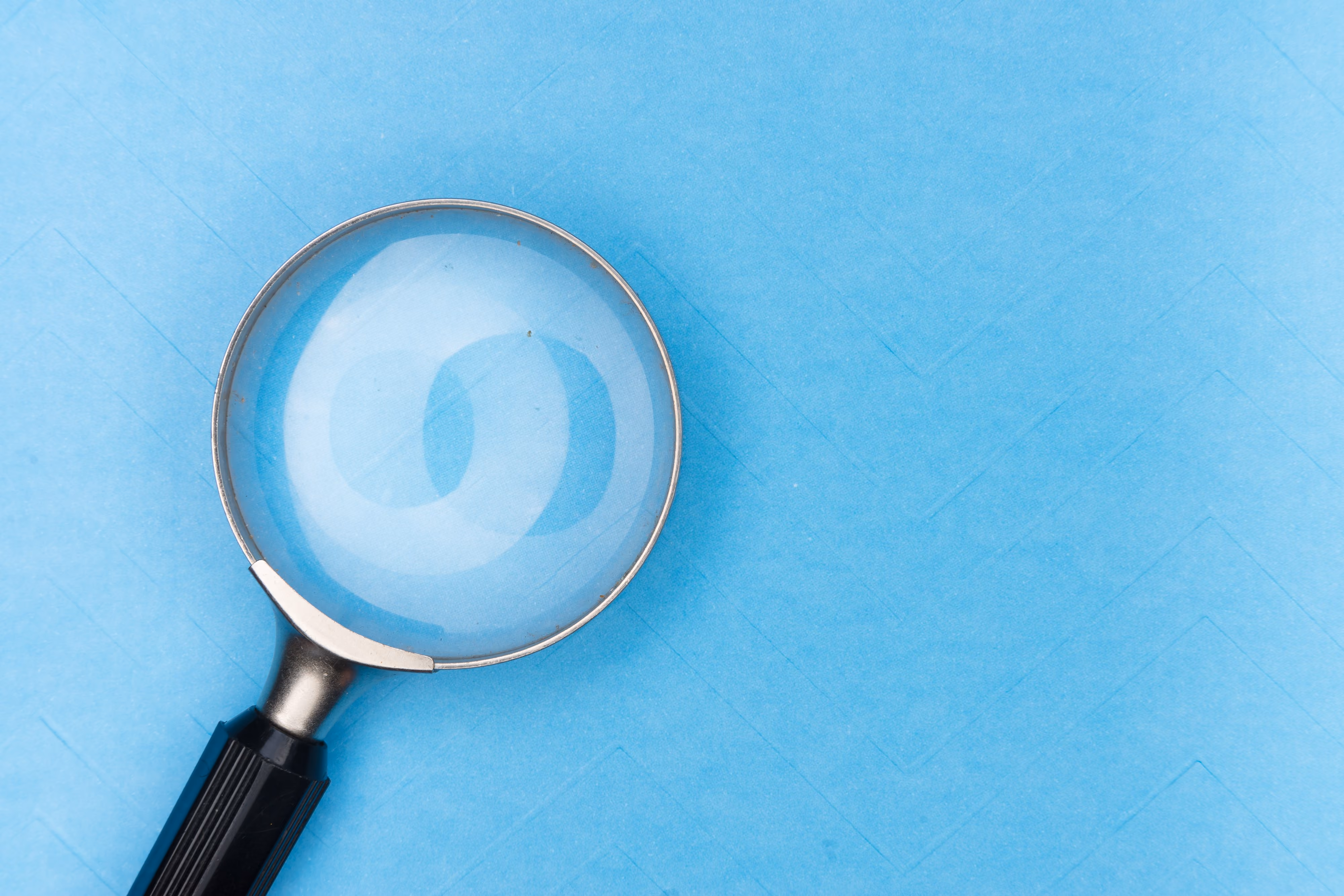Magnifying glass on blue background