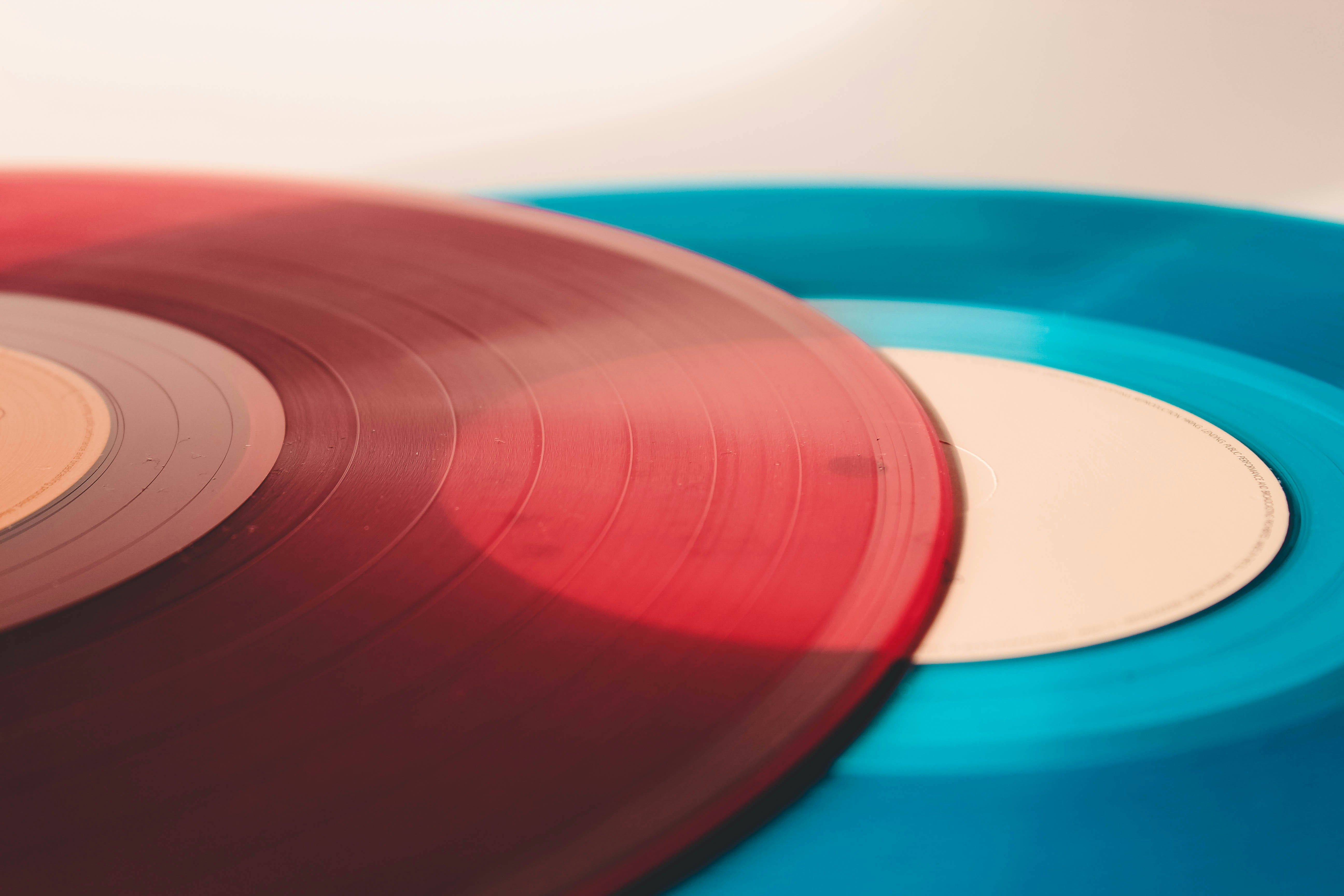 A red vinyl record lying on top of a blue vinyl record