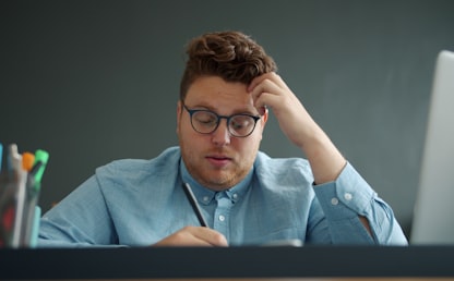 Entrepreneur frustré devant son bureau avec des documents comptables