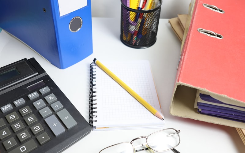 Bureau avec calculatrice, classeurs et cahier pour tenue de livres