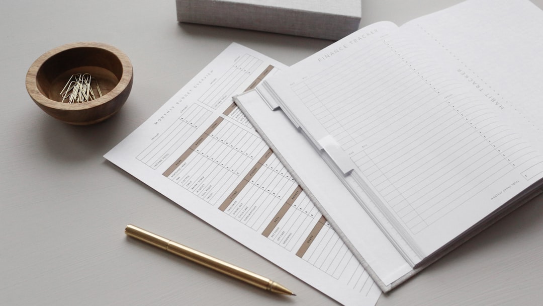 A desk with papers, paper clips, a pen, and a notepad, a symbol of an accountant's administrative work